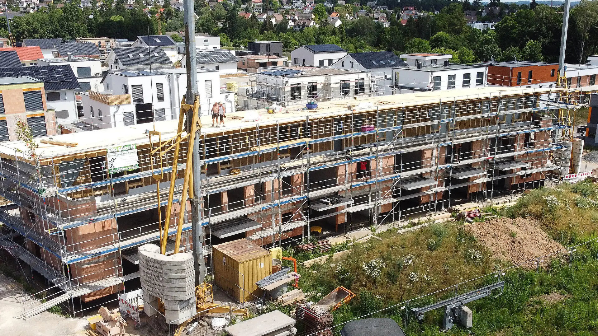 PRODUKTION - 28.06.2022, Hessen, Kassel: Blick auf ein Neubauprojekt eines Mehrfamilienhauses der Genossenschaft "Kassel im Wandel" (Luftaufnahme mit einer Drohne). Die Genossenschaft aus Kassel setzt auf ökologischen Baustoff. Den Strohballenbau gibt es schon seit Ende des 19. Jahrhunderts. Doch lange Zeit war er wenig populär. Dabei sind Strohballen als Dämmstoff günstig, nachhaltig und energetisch hochwertig. Foto: Swen Pförtner/dpa +++ dpa-Bildfunk +++