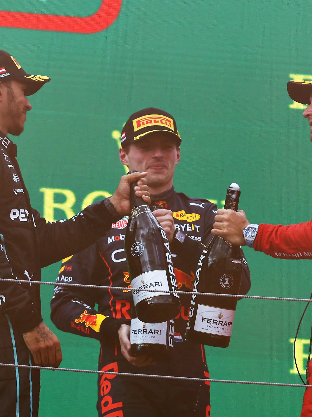 SPIELBERG, AUSTRIA - JULY 10: Race winner Charles Leclerc of Monaco and Ferrari, Second placed Max Verstappen of the Netherlands and Oracle Red Bull Racing and Third placed Lewis Hamilton of Great Britain and Mercedes celebrate on the podium during the F1 Grand Prix of Austria at Red Bull Ring on July 10, 2022 in Spielberg, Austria. (Photo by Clive Rose/Getty Images)