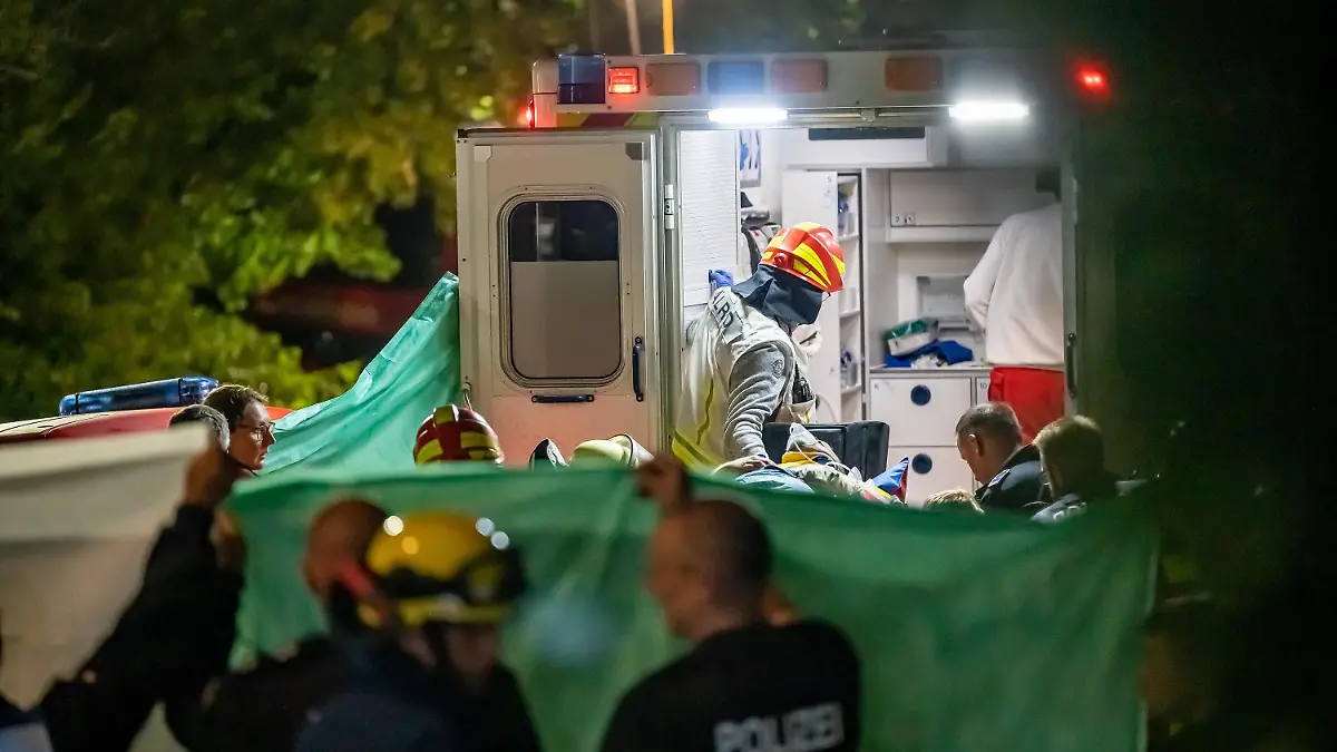 09.07.2022, Hemer: Rettungkräfte tragen einen verletzten Mann in einen Krankenwagen. Nach dem Hauseinsturz im sauerländischen Hemer in Folge einer Explosion sind in der Nacht zum 09.07.2022 zwei weitere Menschen aus den Trümmern gerettet worden. Foto: Markus Klümper/dpa +++ dpa-Bildfunk +++