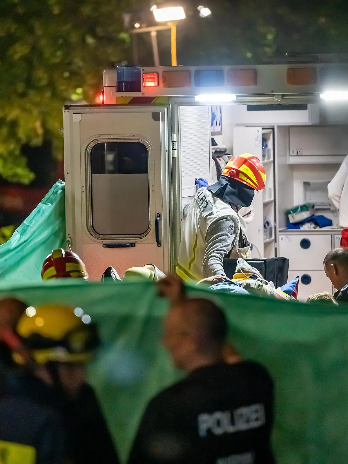 09.07.2022, Hemer: Rettungkräfte tragen einen verletzten Mann in einen Krankenwagen. Nach dem Hauseinsturz im sauerländischen Hemer in Folge einer Explosion sind in der Nacht zum 09.07.2022 zwei weitere Menschen aus den Trümmern gerettet worden. Foto: Markus Klümper/dpa +++ dpa-Bildfunk +++