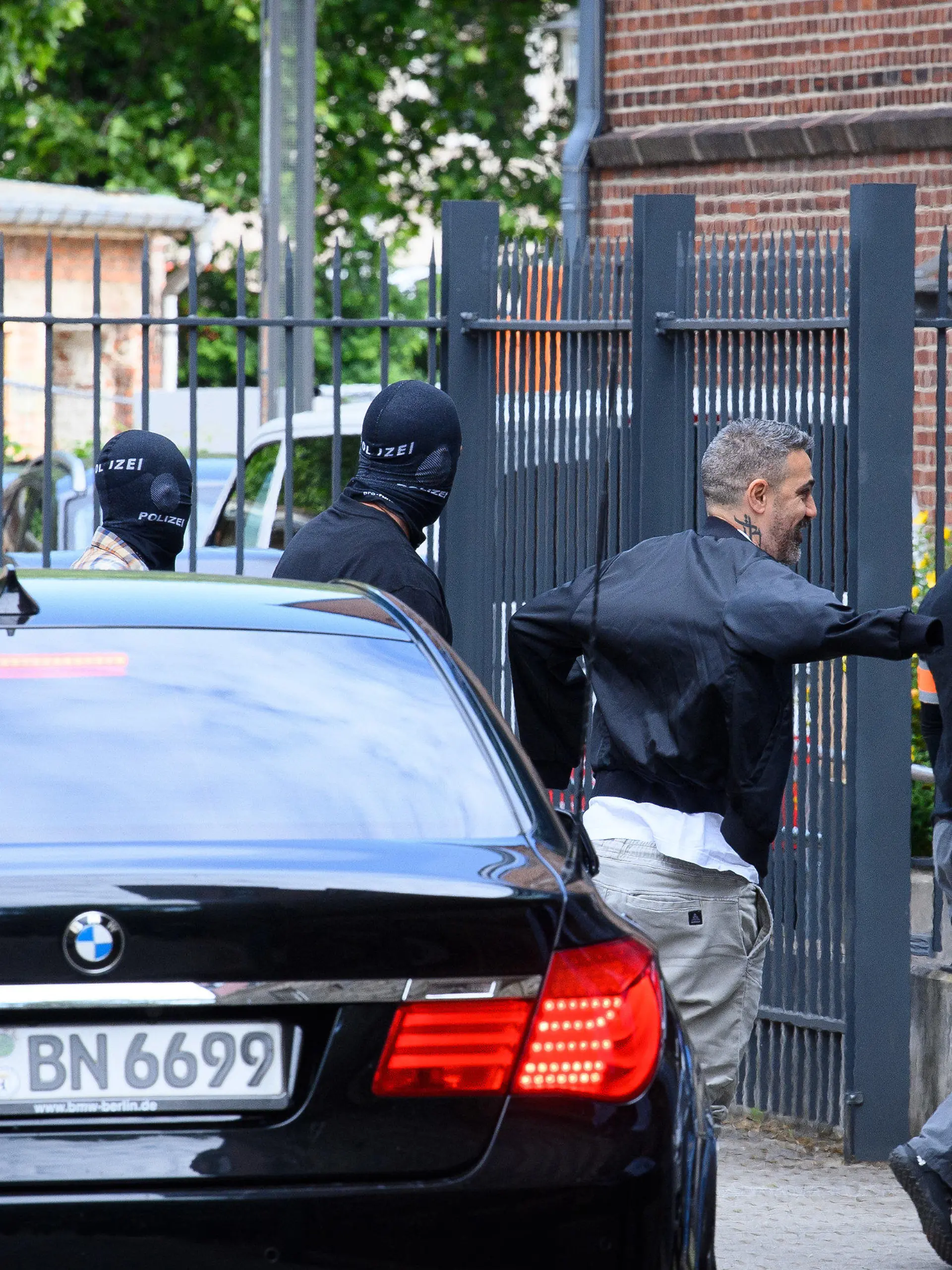 15.06.2022, Brandenburg, Potsdam: Der Rapper Bushido (M) kommt unter Polizeischutz zum Potsdamer Amtsgericht. Die gemeinsame Immobilie des Rappers Bushido und seinem früheren Geschäftspartner soll am Vormittag in Kleinmachnow (Potsdam-Mittelmark) zwangsversteigert werden. In dem Prozess mit Bushido als Nebenkläger und Zeuge steht sein früherer Partner, ein Berliner Clanchef, gemeinsam mit drei seiner Brüder vor Gericht. Foto: Soeren Stache/dpa +++ dpa-Bildfunk +++
