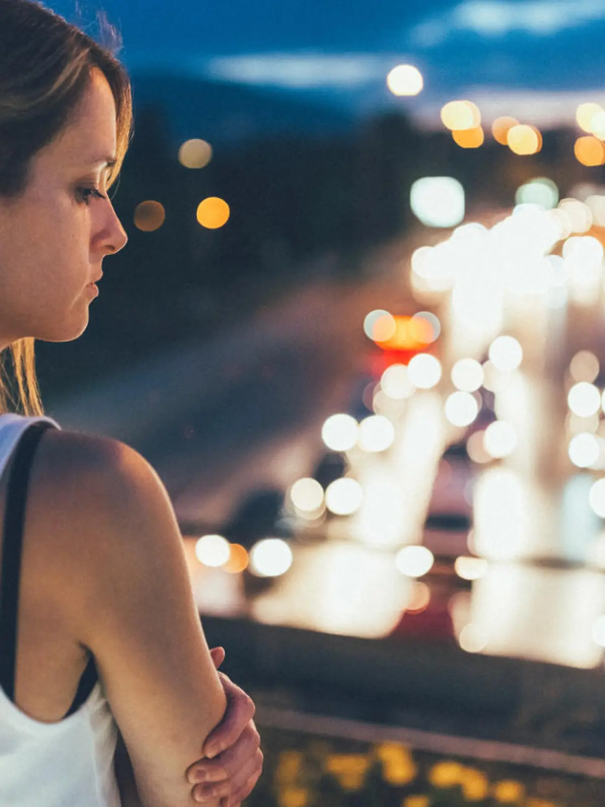 Thoughtful woman outside at night