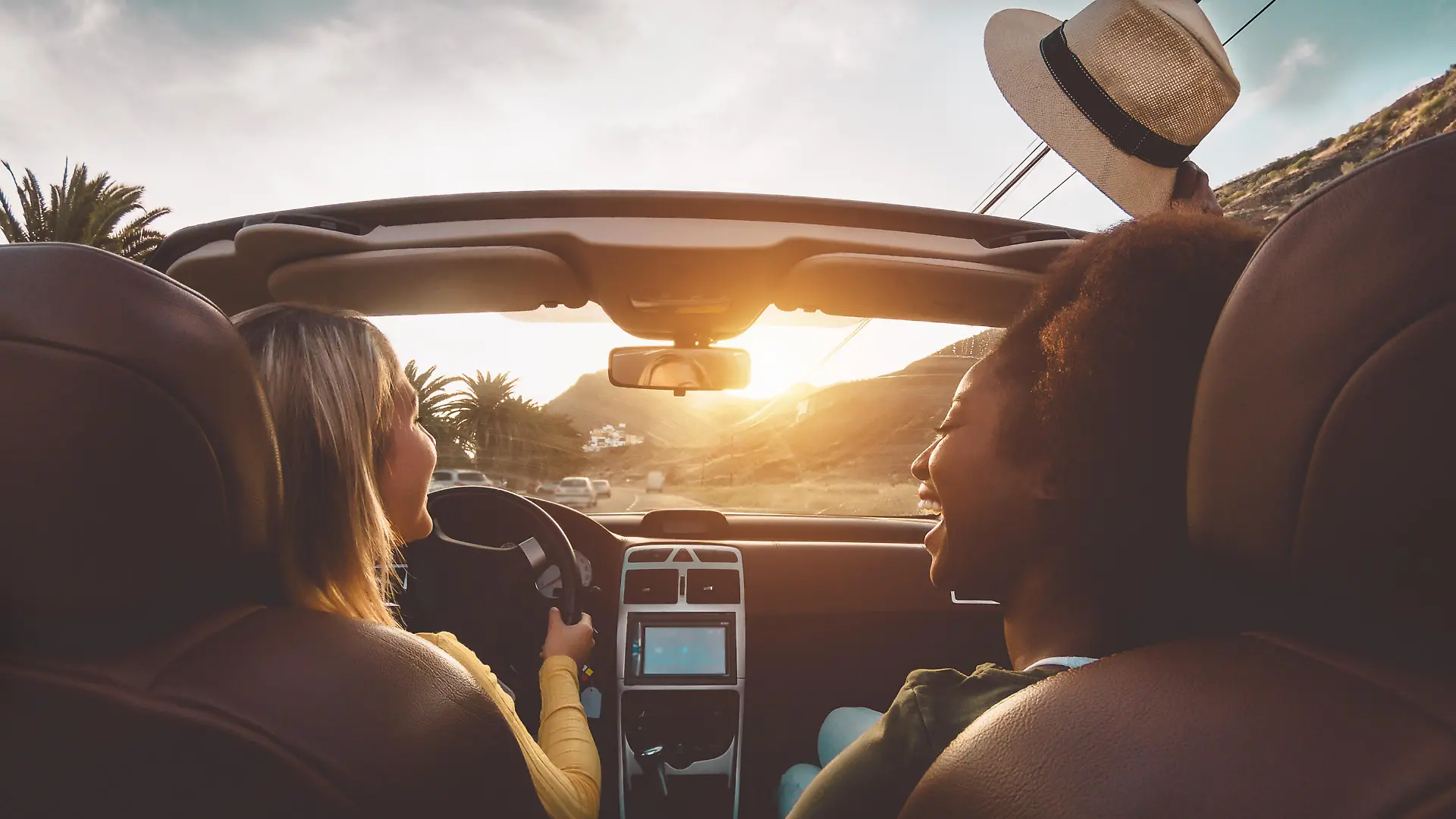 Happy girls doing road trip in tropical city - Travel people having fun driving in trendy convertible car discovering new places - Friendship and youth girlfriends vacation lifestyle concept