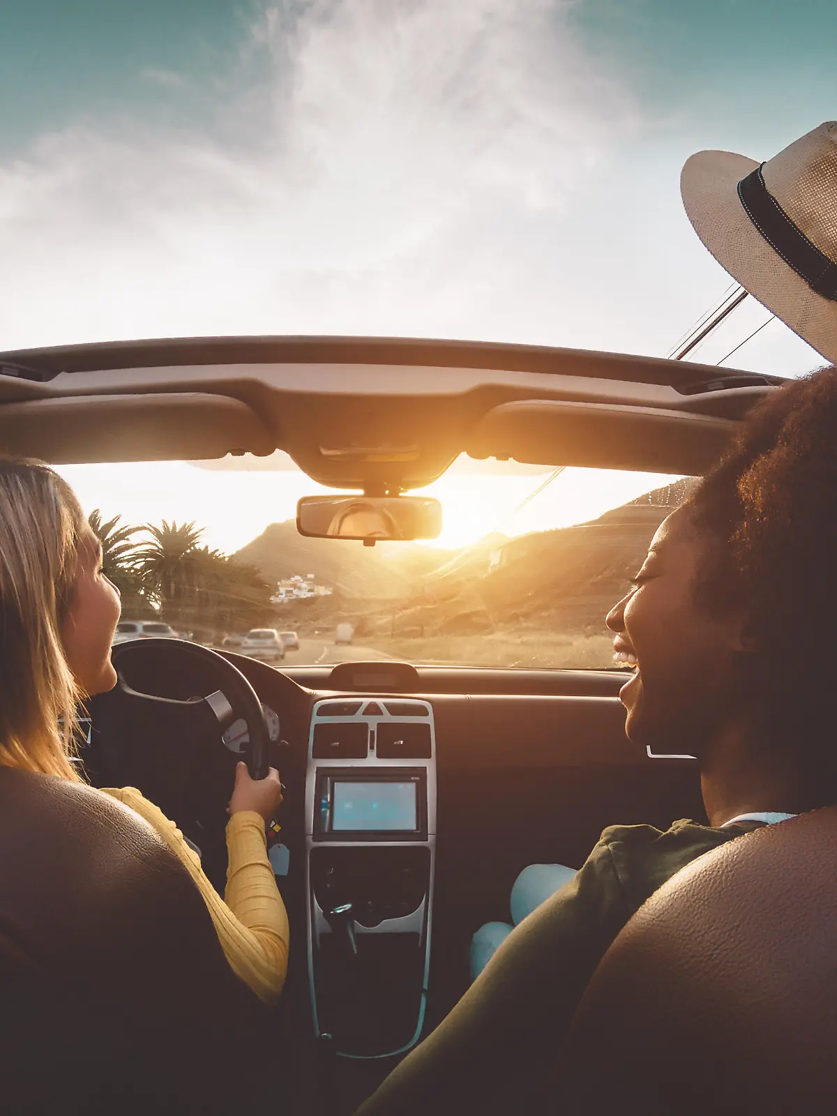 Happy girls doing road trip in tropical city - Travel people having fun driving in trendy convertible car discovering new places - Friendship and youth girlfriends vacation lifestyle concept