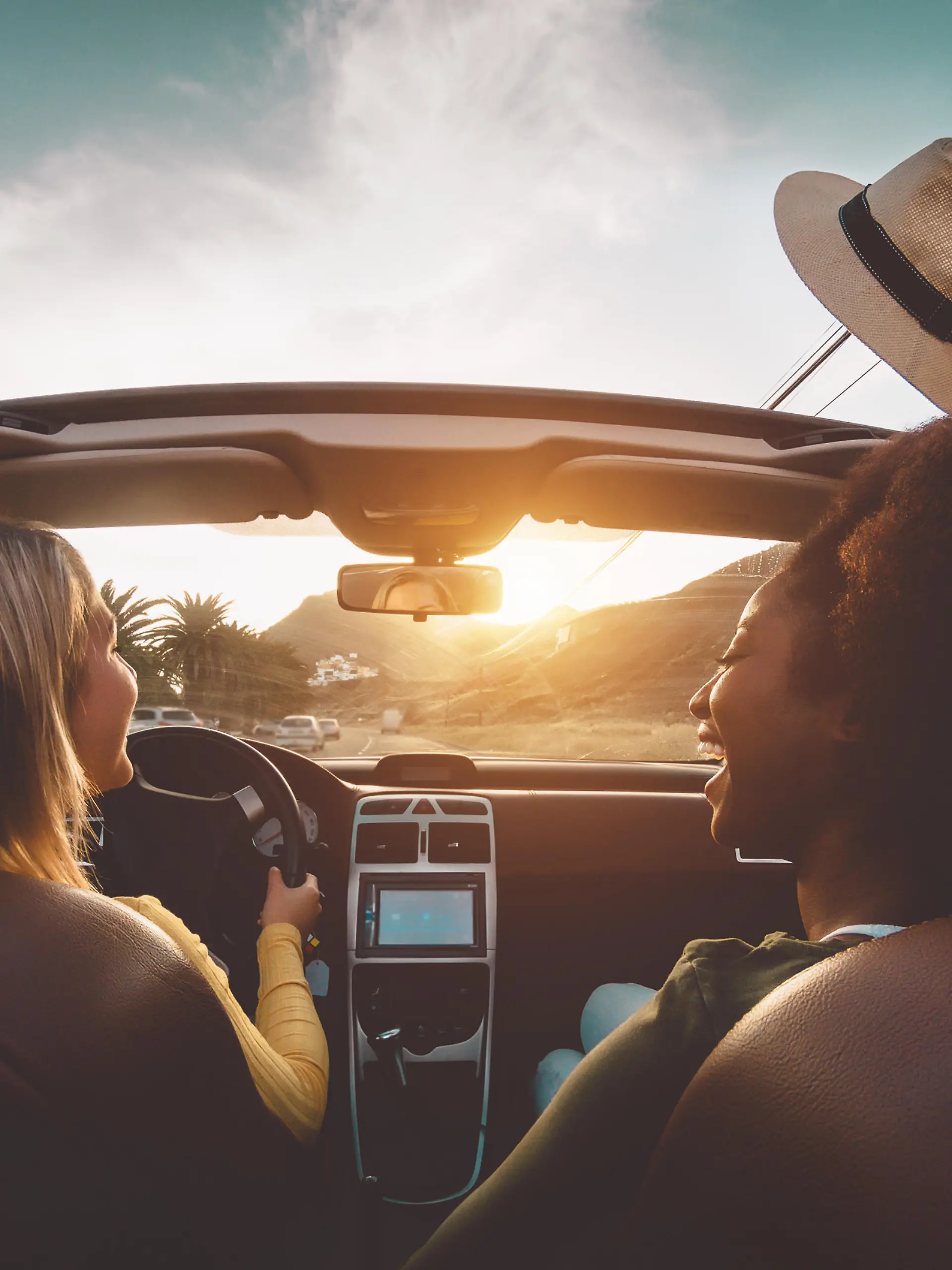 Happy girls doing road trip in tropical city - Travel people having fun driving in trendy convertible car discovering new places - Friendship and youth girlfriends vacation lifestyle concept