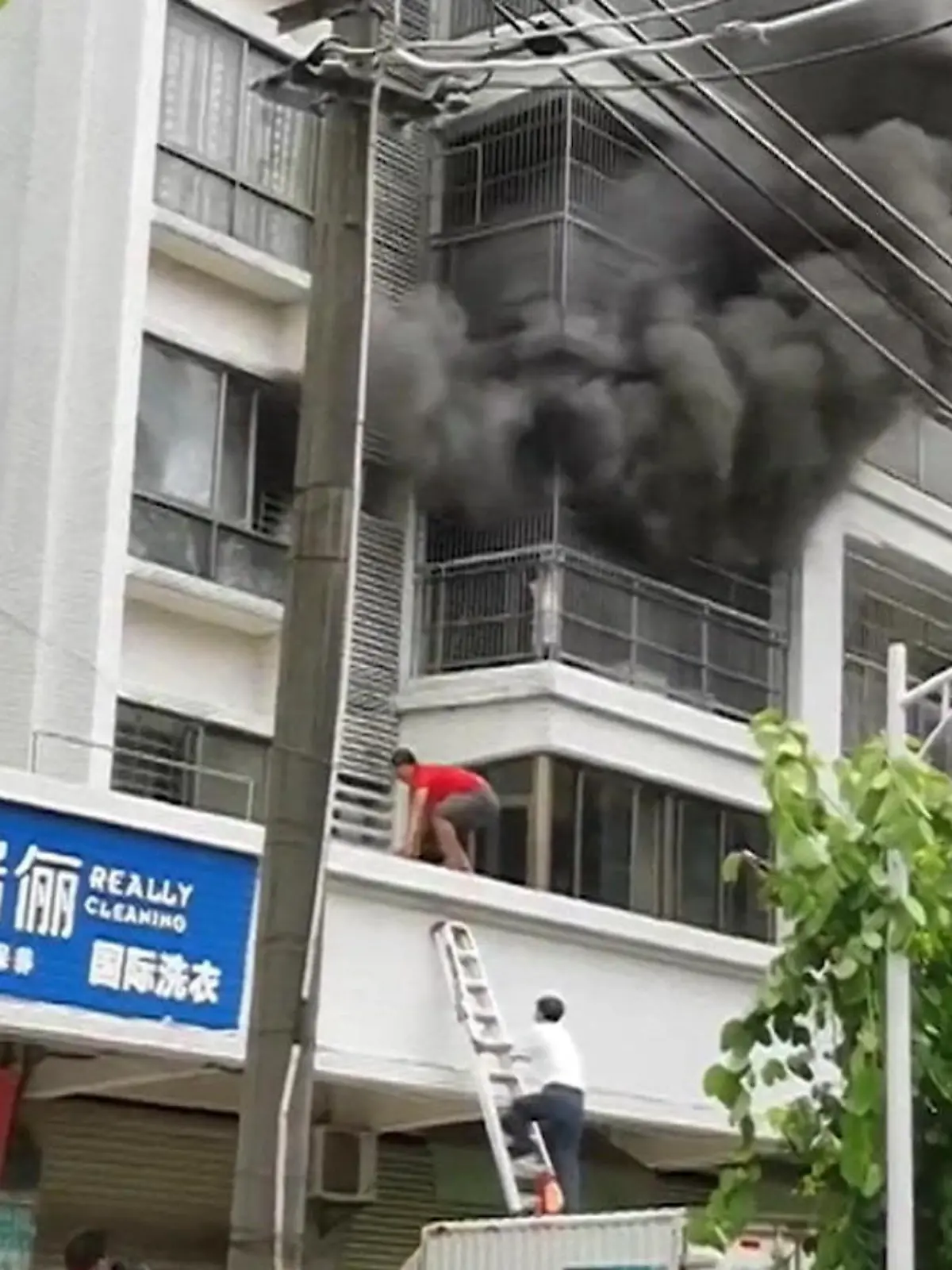 In letzter Sekunde gerettet! Ein sechsjähriger Junge kämpft sich während eines Großbrandes in einem Wohnhaus in Südchina gerade noch so auf den Balkon. Doch das Geländer ist einfach zu hoch. Der Junge ist gefangen.