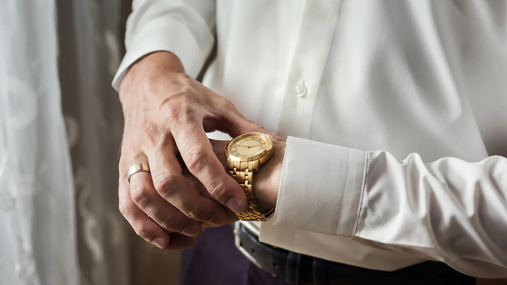 businessman checking time on his wrist watch, man putting clock on hand,groom getting ready in the morning before wedding ceremony