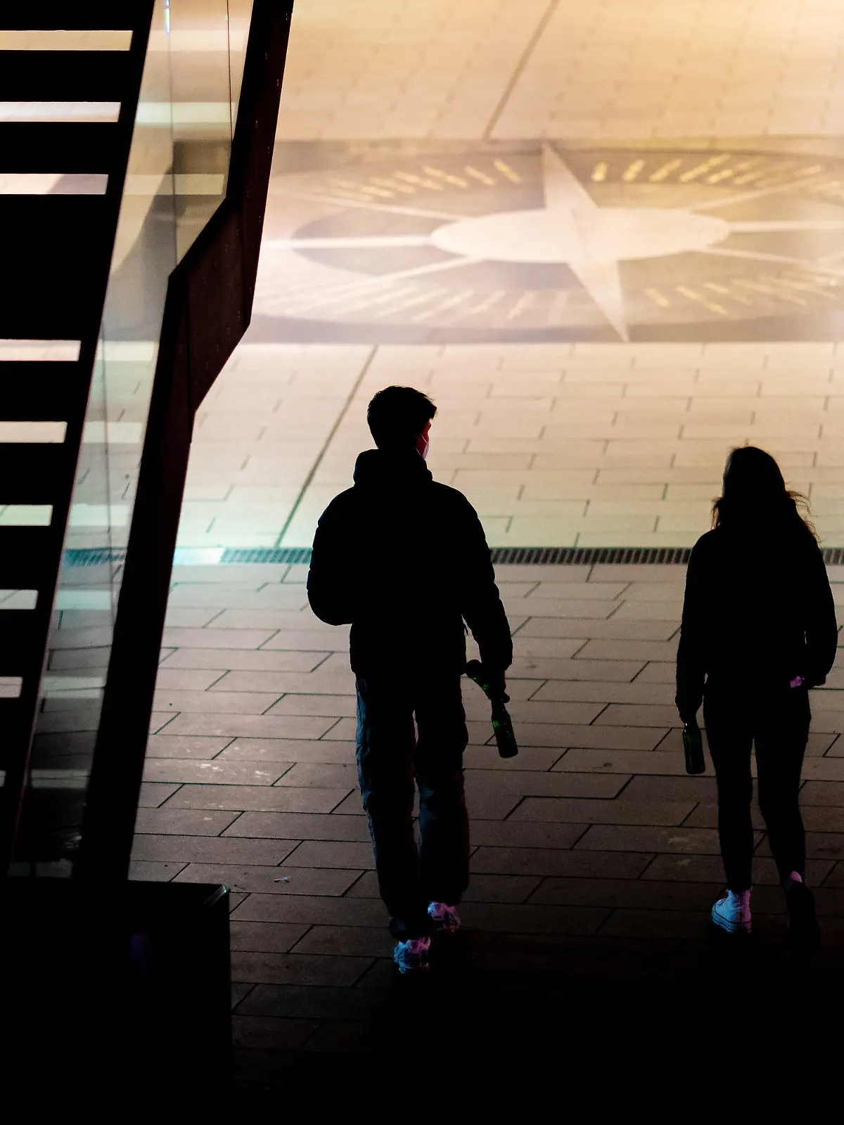 ARCHIV - 01.04.2021, Niedersachsen, Hannover: Zwei junge Menschen gehen am Abend mit Flaschen in den Händen kurz vor Beginn der Ausgangsbeschränkungen zur Eindämmung der Corona-Pandemie durch die Innenstadt. Wie denken Jugendliche und junge Erwachsene in Europa über ihr Leben in der Dauer-Krise? (zu dpa: «Studie: Krieg in Europa ist größte Sorge junger Menschen») Foto: Moritz Frankenberg/dpa +++ dpa-Bildfunk +++