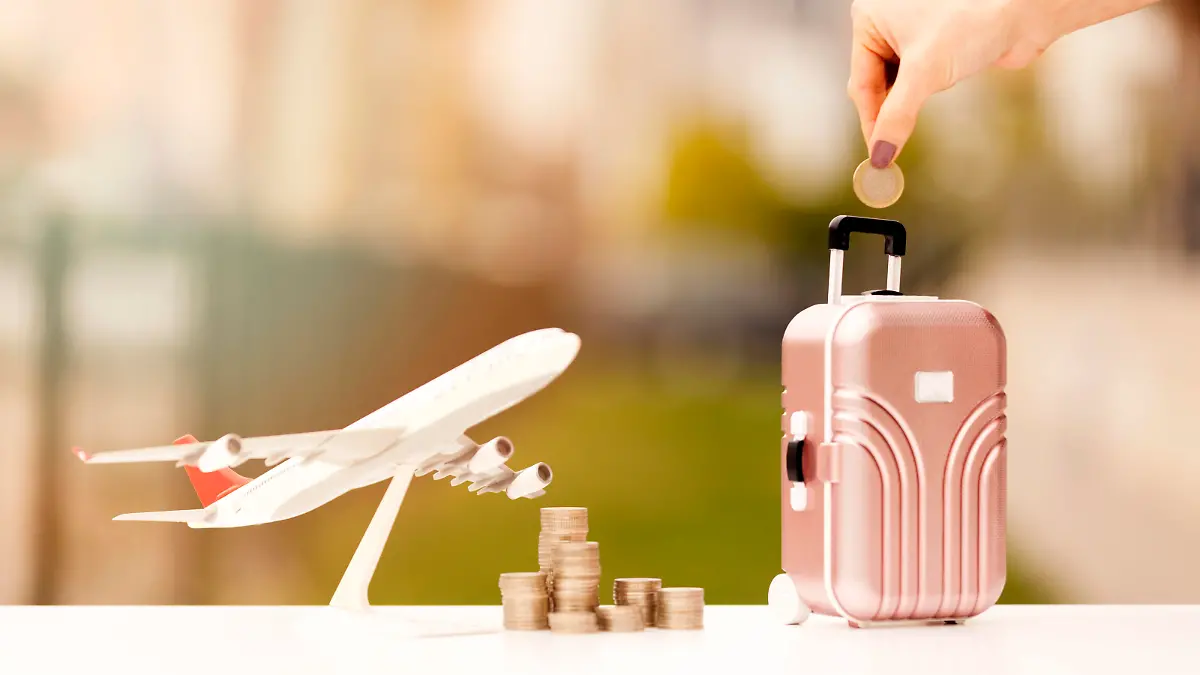 Miniature toy airplane and suitcases on bokeh background