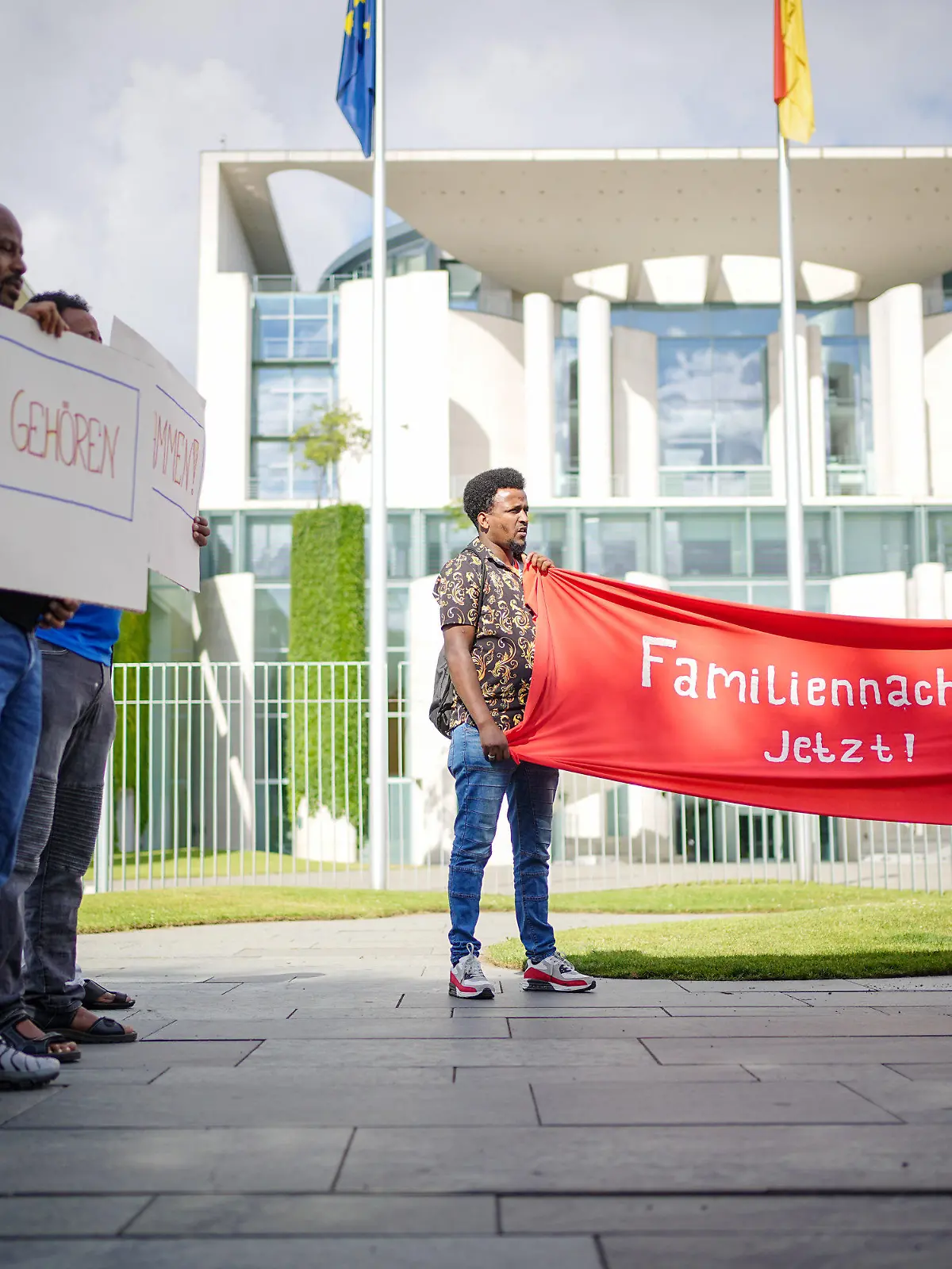 06.07.2022, Berlin: Mit Plakaten demonstrieren am Morgen Teilnehmer für den Familiennachzug vor dem Bundeskanzleramt. Das Bundeskabinett will in seiner Sitzung das erste Migrationspaket der Ampel-Regierung auf den Weg bringen. Foto: Kay Nietfeld/dpa +++ dpa-Bildfunk +++