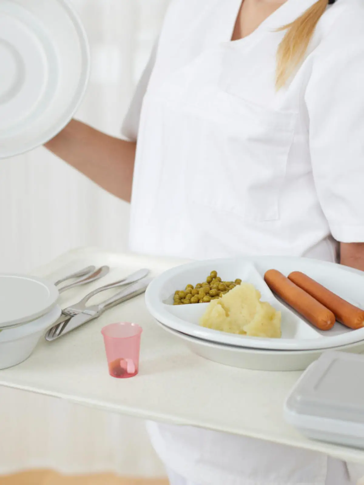 Friendly nurse is serving hospital food