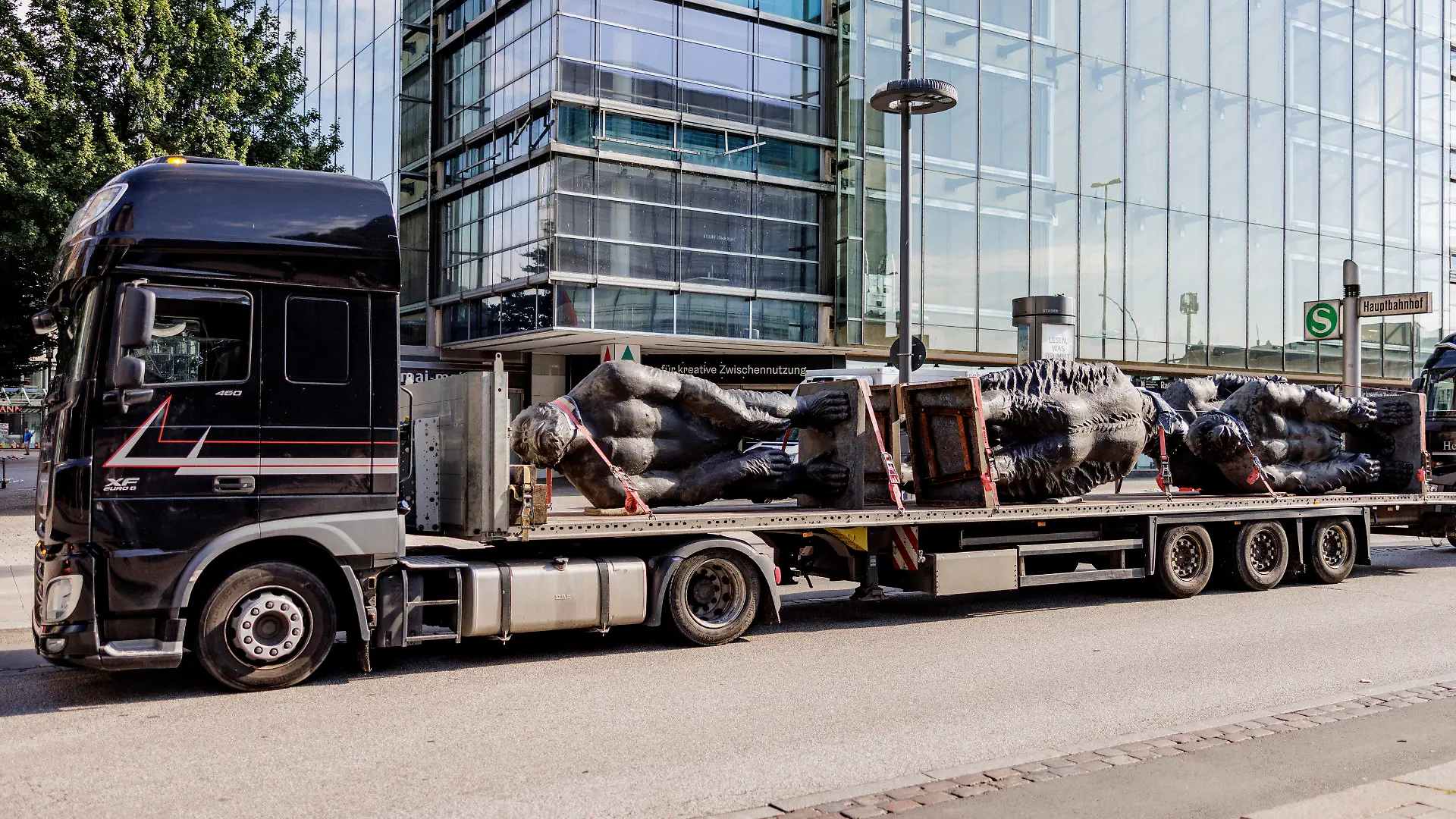 03.07.2022, Hamburg: Über drei Meter große Skulpturen von Affen des chinesischen Künstlers Liu Ruowang werden von Technikern von Tiefladern abgeladen und aufgestellt. Insgesamt Zwölf Figuren werden in der Mönkebergstraße ausgestellt. Foto: Axel Heimken/dpa - ACHTUNG: Nur zur redaktionellen Verwendung im Zusammenhang mit der aktuellen Berichterstattung +++ dpa-Bildfunk +++