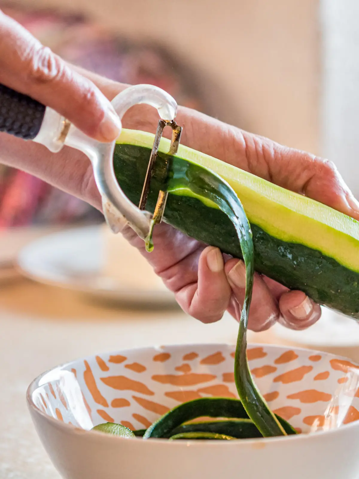 Woman Hands Peeling Cucumber for Making Fresh Mediterranean Salad