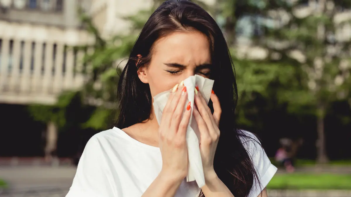 a young woman in the park has a cough and allergy