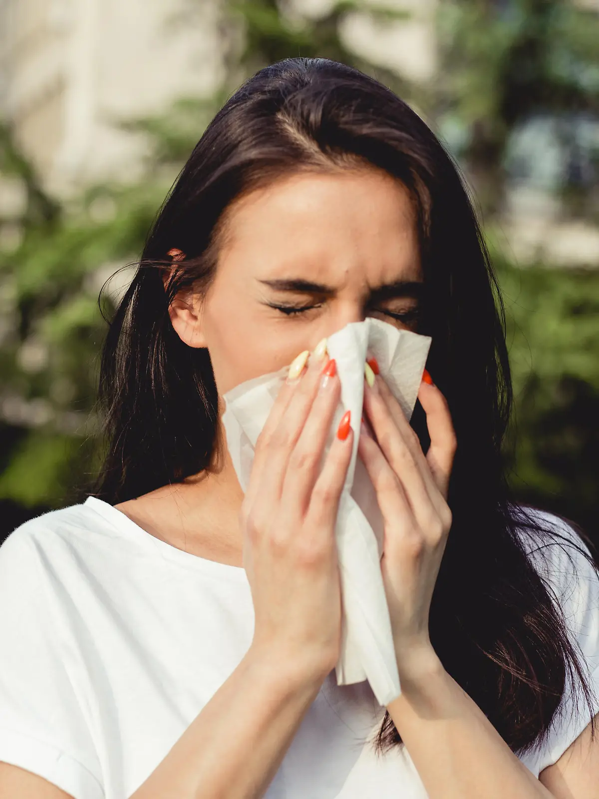a young woman in the park has a cough and allergy