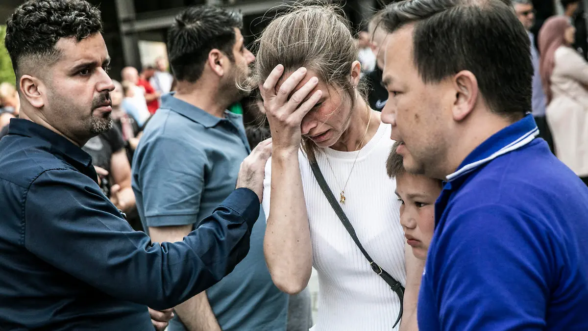 03.07.2022, Dänemark, Kopenhagen: Menschen reagieren vor dem Field's-Einkaufszentrum in Kopenhagen, Dänemark. Ein bewaffneter Mann eröffnete am Sonntag das Feuer in dem belebten Einkaufszentrum in der dänischen Hauptstadt und tötete einige Menschen und verletzte einige andere schwer, so die Polizei. Foto: Olafur Steinar Rye Gestsson/Ritzau Scanpix Foto via AP/dpa - ACHTUNG: Nur zur redaktionellen Verwendung und nur mit vollständiger Nennung des vorstehenden Credits +++ dpa-Bildfunk +++