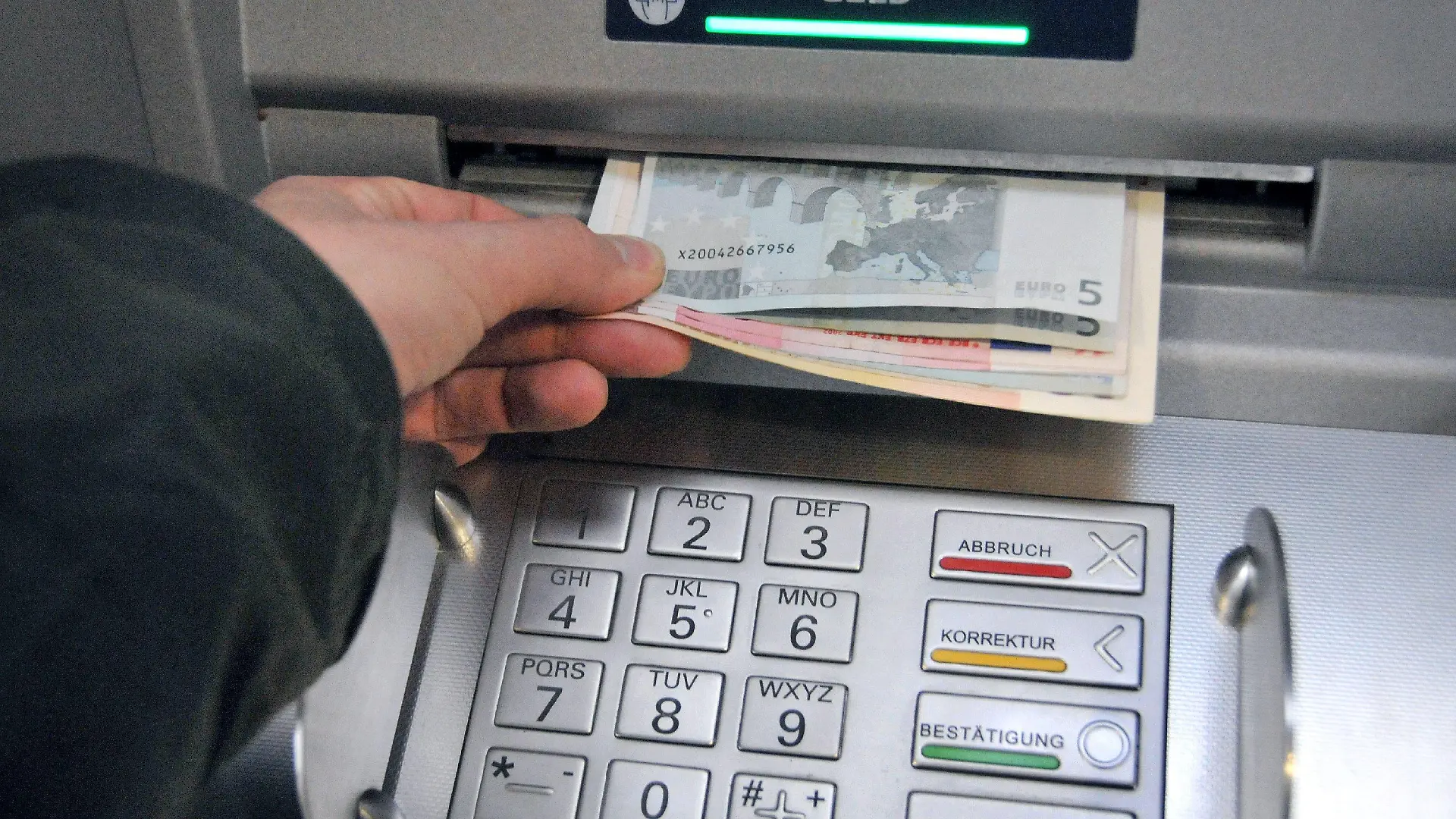 ARCHIV - Eine Hand entnimmt dem Geldschlitz eines Bankautomaten die gewünschten Banknoten (Archivfoto vom 07.11.2008). Geldautomaten in Deutschland werden immer häufiger manipuliert. Wie das Bundeskriminalamt (BKA) am Mittwoch (21.01.2009) in Wiesbaden berichtete, stieg die Zahl der Fälle im vergangenen Jahr stark an. Bundesweit hätten sich an 809 verschiedenen Geldautomaten Kriminelle zu schaffen gemacht, das entspricht einer Steigerung im Vergleich zum Vorjahr um 77 Prozent. Die Betrügereien verursachten einen Schaden von schätzungsweise mehr als 40 Millionen Euro. Foto: Uwe Zucchi (zu dpa 0460 vom 21.01.2009) +++(c) dpa - Bildfunk+++