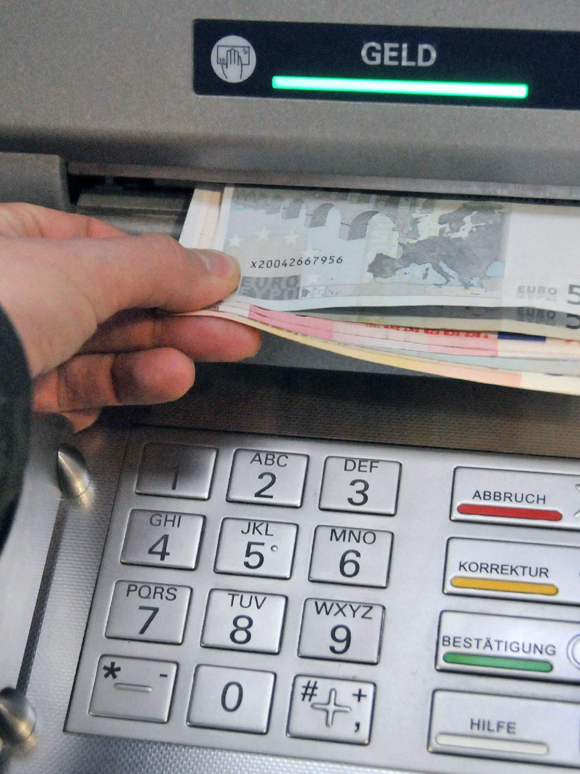 ARCHIV - Eine Hand entnimmt dem Geldschlitz eines Bankautomaten die gewünschten Banknoten (Archivfoto vom 07.11.2008). Geldautomaten in Deutschland werden immer häufiger manipuliert. Wie das Bundeskriminalamt (BKA) am Mittwoch (21.01.2009) in Wiesbaden berichtete, stieg die Zahl der Fälle im vergangenen Jahr stark an. Bundesweit hätten sich an 809 verschiedenen Geldautomaten Kriminelle zu schaffen gemacht, das entspricht einer Steigerung im Vergleich zum Vorjahr um 77 Prozent. Die Betrügereien verursachten einen Schaden von schätzungsweise mehr als 40 Millionen Euro. Foto: Uwe Zucchi (zu dpa 0460 vom 21.01.2009) +++(c) dpa - Bildfunk+++