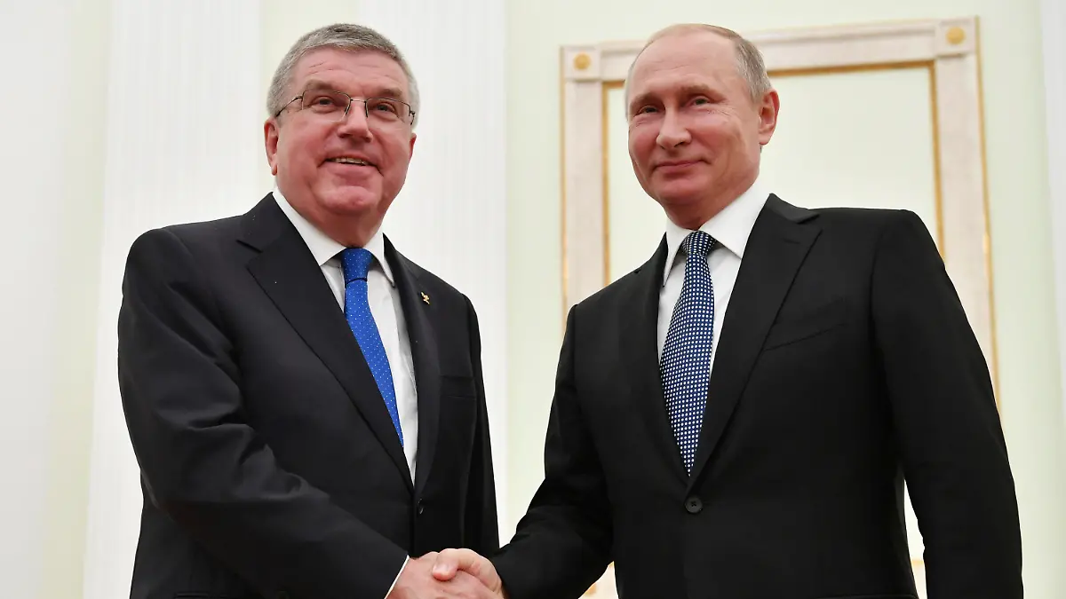 ARCHIV - 15.07.2018, Russland, Moskau: Wladimir Putin (r), Präsident von Russland, gibt Thomas Bach, IOC-Präsident, bei einem Treffen im Kreml die Hand, wenige Stunden vor dem Finale der Fußball-WM zwischen Frankreich und Kroatien. Der IOC-Chef hat nach Angaben eines Sprechers nie einen Orden vom russischen Präsidenten erhalten (zu dpa «IOC-Sprecher: Bach hat nie Orden von Putin erhalten») Foto: Yuri Kadobnov/POOL AFP/dpa +++ dpa-Bildfunk +++