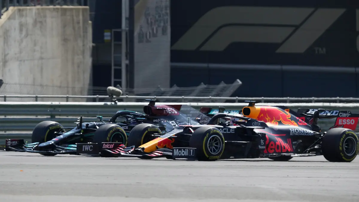 Mercedes driver Lewis Hamilton of Britain, left, and Red Bull driver Max Verstappen of the Netherlands take a curve side-by-side at the start of the British Formula One Grand Prix, at the Silverstone circuit, in Silverstone, England, Sunday, July 18, 2021. (AP Photo/Jon Super)