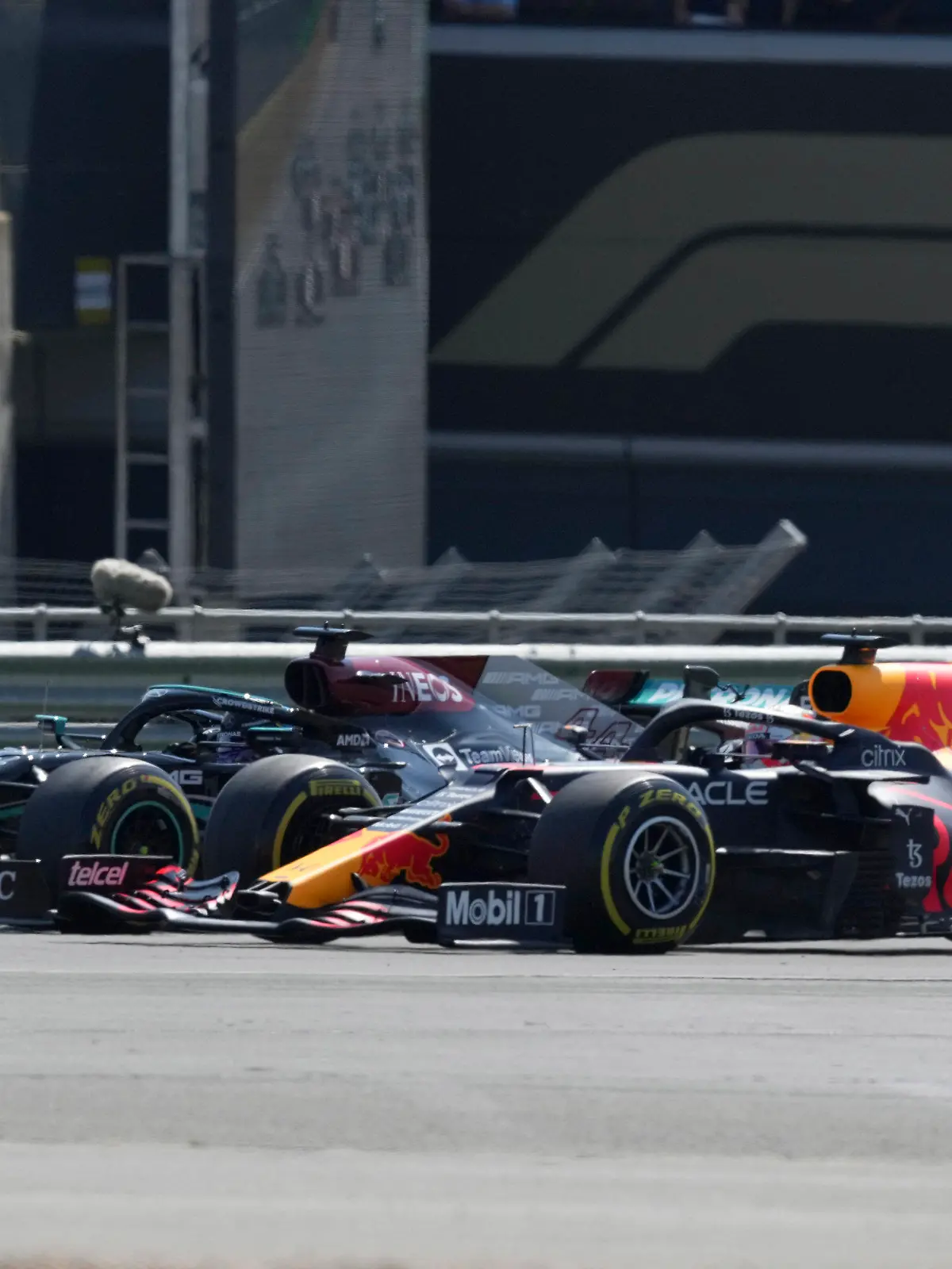 Mercedes driver Lewis Hamilton of Britain, left, and Red Bull driver Max Verstappen of the Netherlands take a curve side-by-side at the start of the British Formula One Grand Prix, at the Silverstone circuit, in Silverstone, England, Sunday, July 18, 2021. (AP Photo/Jon Super)