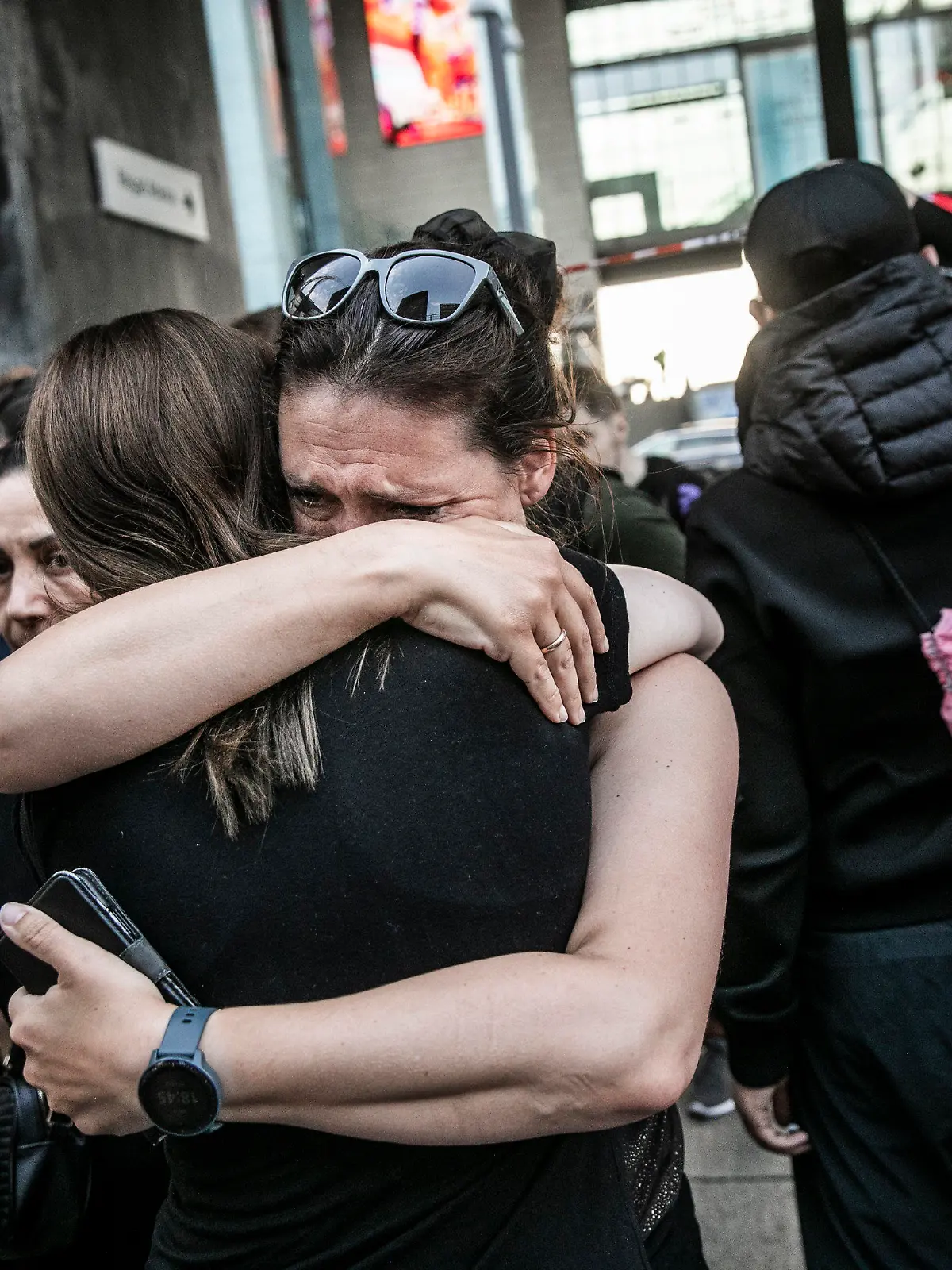 03.07.2022, Dänemark, Kopenhagen: Zwei Menschen umarmen sich vor dem Einkaufszentrum Fields in Kopenhagen, Dänemark. Ein bewaffneter Mann eröffnete am Sonntag das Feuer in dem belebten Einkaufszentrum in der dänischen Hauptstadt und tötete einige Menschen und verletzte einige andere schwer, so die Polizei. Foto: Olafur Steinar Rye Gestsson/Ritzau Scanpix Foto via AP/dpa - ACHTUNG: Nur zur redaktionellen Verwendung und nur mit vollständiger Nennung des vorstehenden Credits +++ dpa-Bildfunk +++