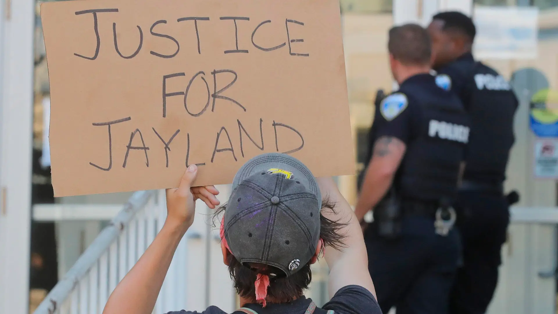 Akron Police Officers are confronted by protesters as they enter the Stubbs Justice Center during a protest over the Akron police shooting death of Jayland Walker on Thursday, June 30, 2022, in Akron, Ohio. Walkler, shot and killed by police following a vehicle and foot pursuit this week died from multiple gunshot wounds, and his death has been ruled a homicide, authorities announced Wednesday.(Jeff Lange /Akron Beacon Journal via AP)