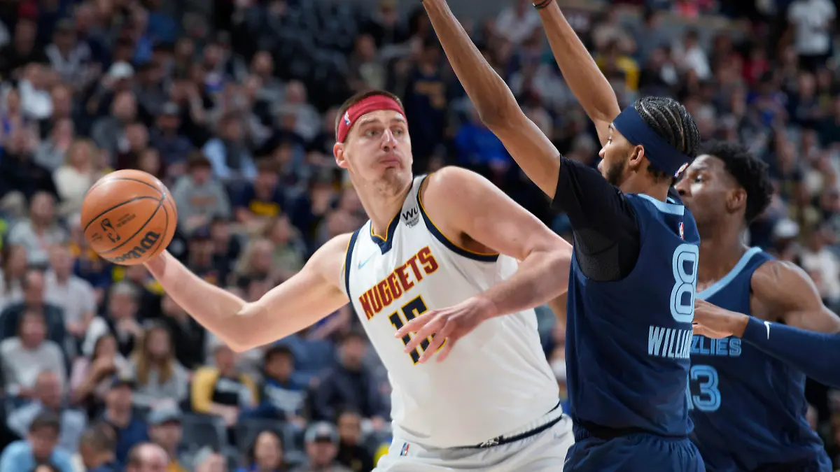 FILE - Denver Nuggets center Nikola Jokic looks to pass the ball as Memphis Grizzlies guard Ziaire Williams, front, and forward Jaren Jackson Jr. defend during the first half of an NBA basketball game April 7, 2022, in Denver. Jokic and the Nuggets agreed Thursday, June 30, to a $264 supermax extension, according to a person with direct knowledge of the negotiations who spoke to The Associated Press on condition of anonymity because neither the player nor team announced the agreement. (AP Photo/David Zalubowski, File)