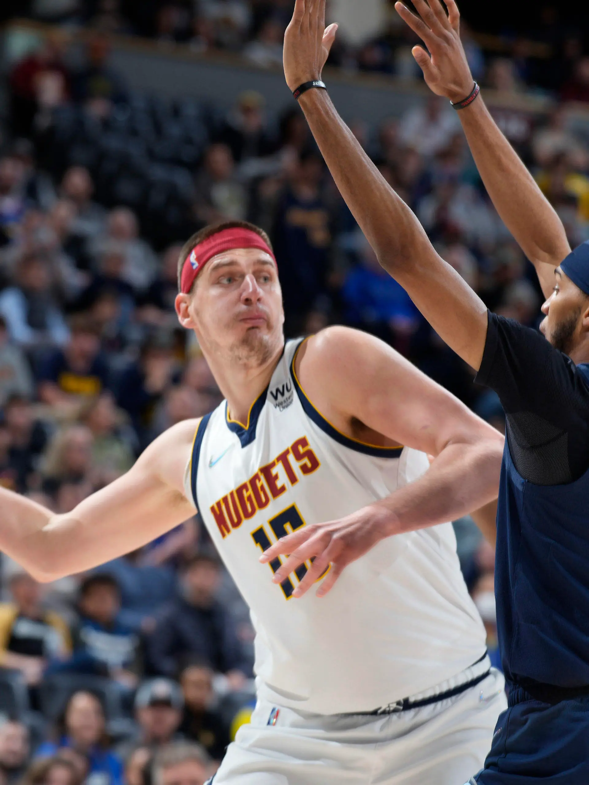 FILE - Denver Nuggets center Nikola Jokic looks to pass the ball as Memphis Grizzlies guard Ziaire Williams, front, and forward Jaren Jackson Jr. defend during the first half of an NBA basketball game April 7, 2022, in Denver. Jokic and the Nuggets agreed Thursday, June 30, to a $264 supermax extension, according to a person with direct knowledge of the negotiations who spoke to The Associated Press on condition of anonymity because neither the player nor team announced the agreement. (AP Photo/David Zalubowski, File)