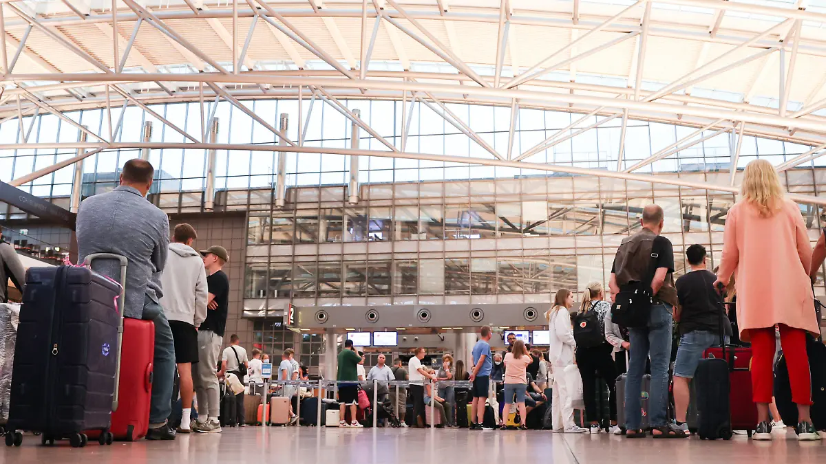 01.07.2022, Hamburg: Flugreisende stehen vor den Check-In-Schaltern in Terminal 1 am Airport Hamburg. Mit dem Beginn der Sommerferien in Schleswig-Holstein, Mecklenburg-Vorpommern und Hamburg erwartet der Flughafen der Hansestadt einen Ansturm von Passagieren Foto: Christian Charisius/dpa +++ dpa-Bildfunk +++