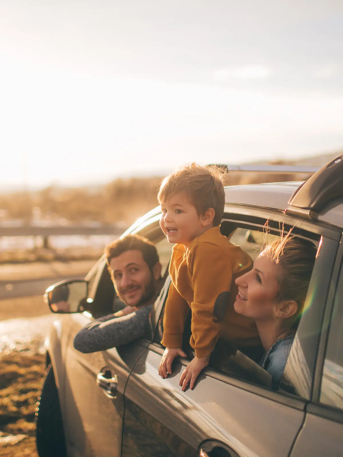 Photo of cute little family during their excursion with family car