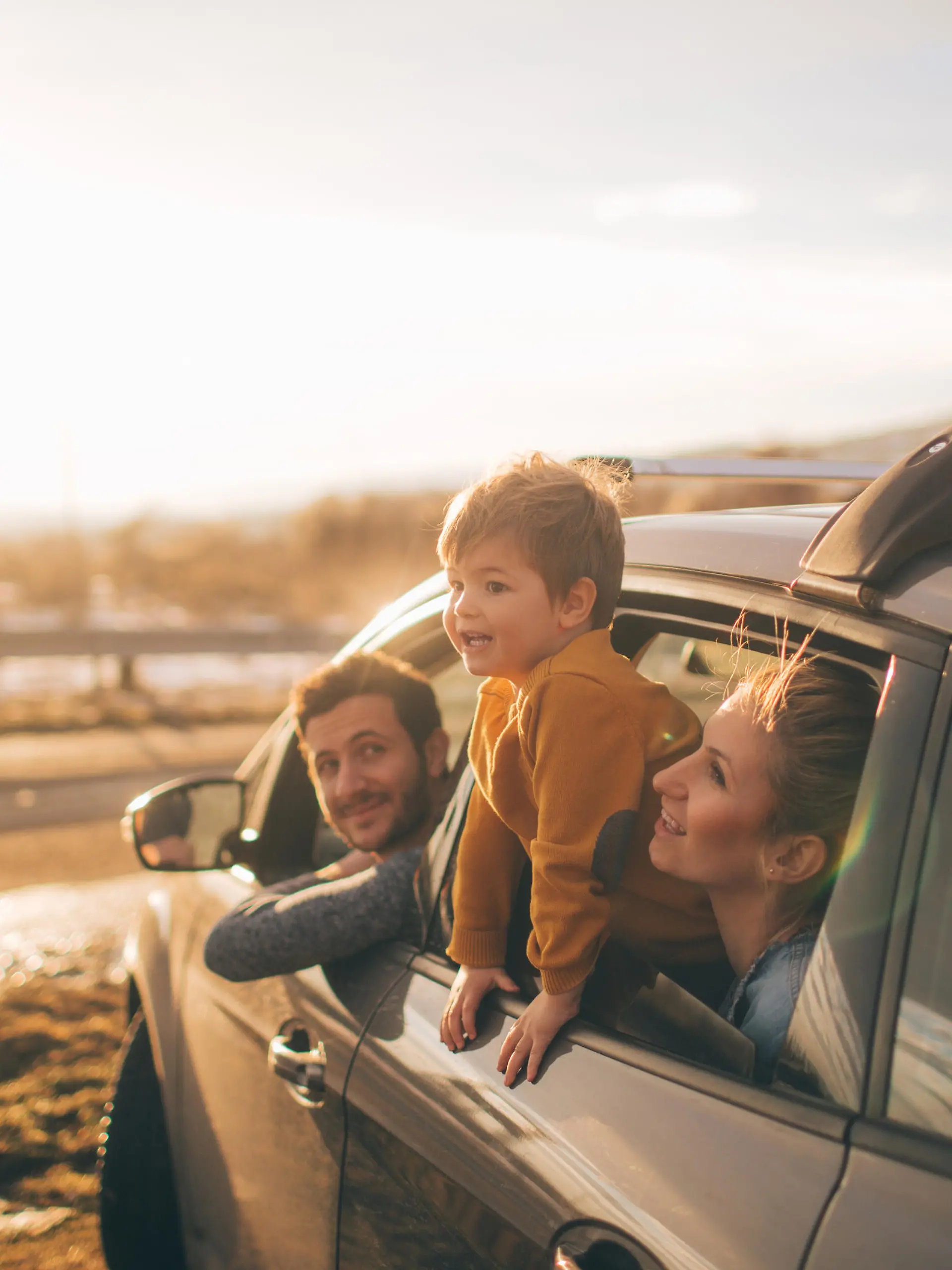 Photo of cute little family during their excursion with family car