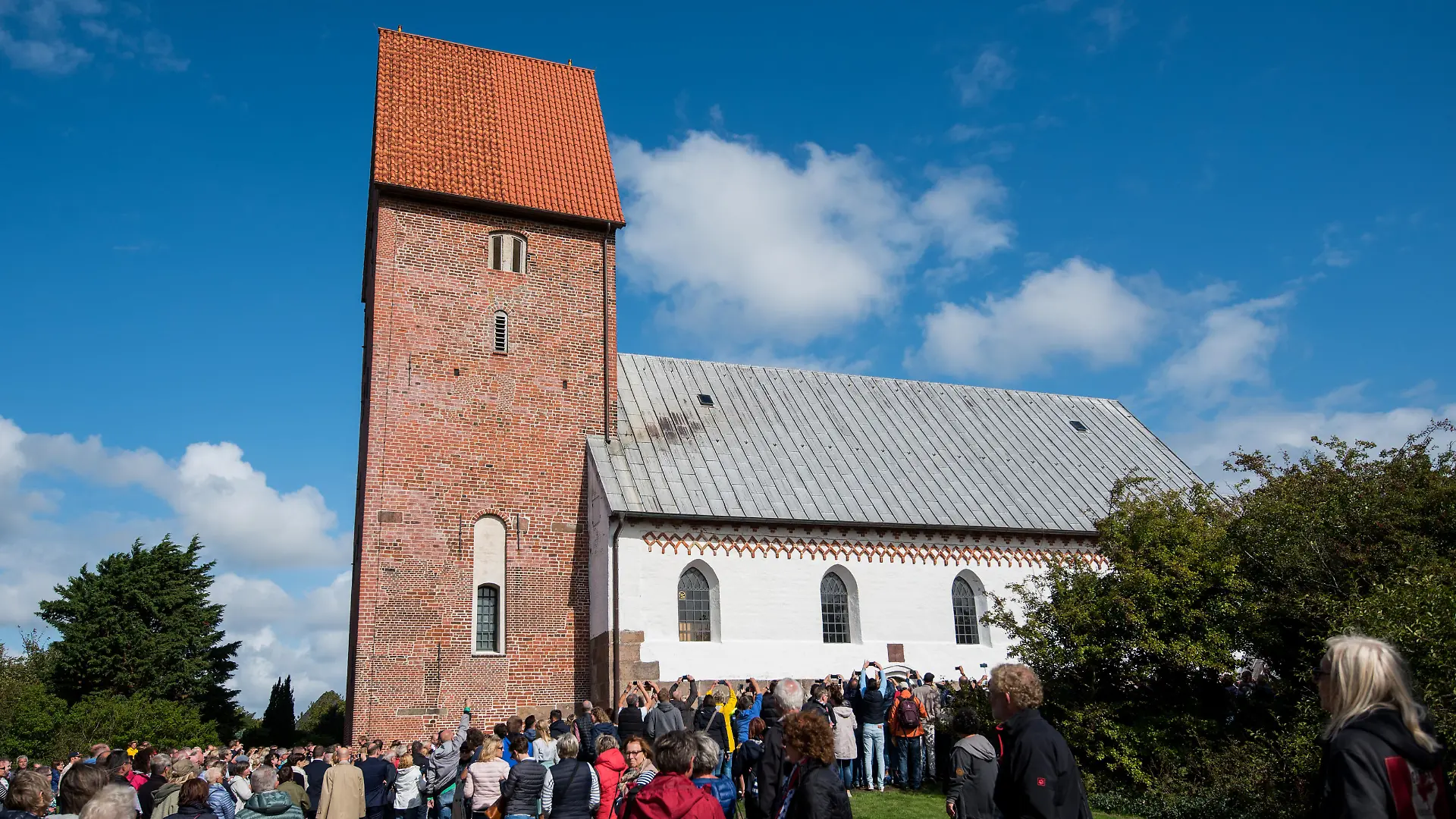 08.09.2018, Schleswig-Holstein, Sylt, Keitum: Zahlreiche Schaulustige warten während der Hochzeit von Modedesigner Guido Maria Kretschmer und Frank Mutters vor der Kirche St. Severin. Foto: Daniel Bockwoldt/dpa