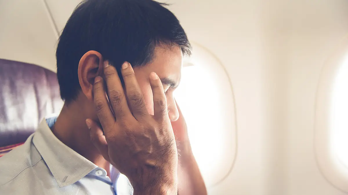 Male passenger having ear pop on the airplane while taking off (or landing)