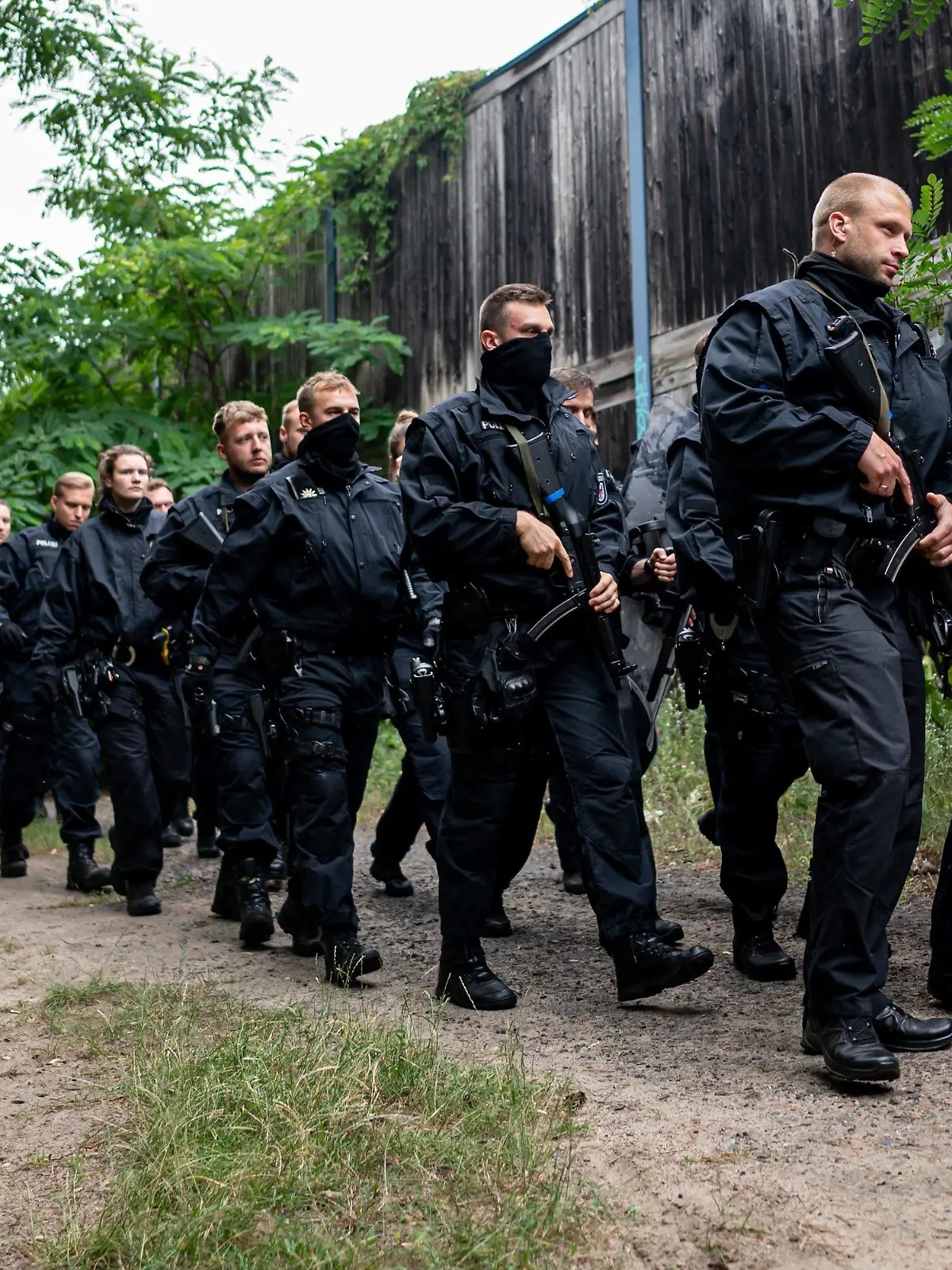 21.07.2023, Brandenburg, Kleinmachnow: Polizisten laufen im Bereich der südlichen Landesgrenze von Berlin. Ein gefährliches Wildtier soll in der Nacht zum Donnerstag in Brandenburg entlaufen sein und hat eine große Suchaktion ausgelöst. Foto: Fabian Sommer/dpa +++ dpa-Bildfunk +++