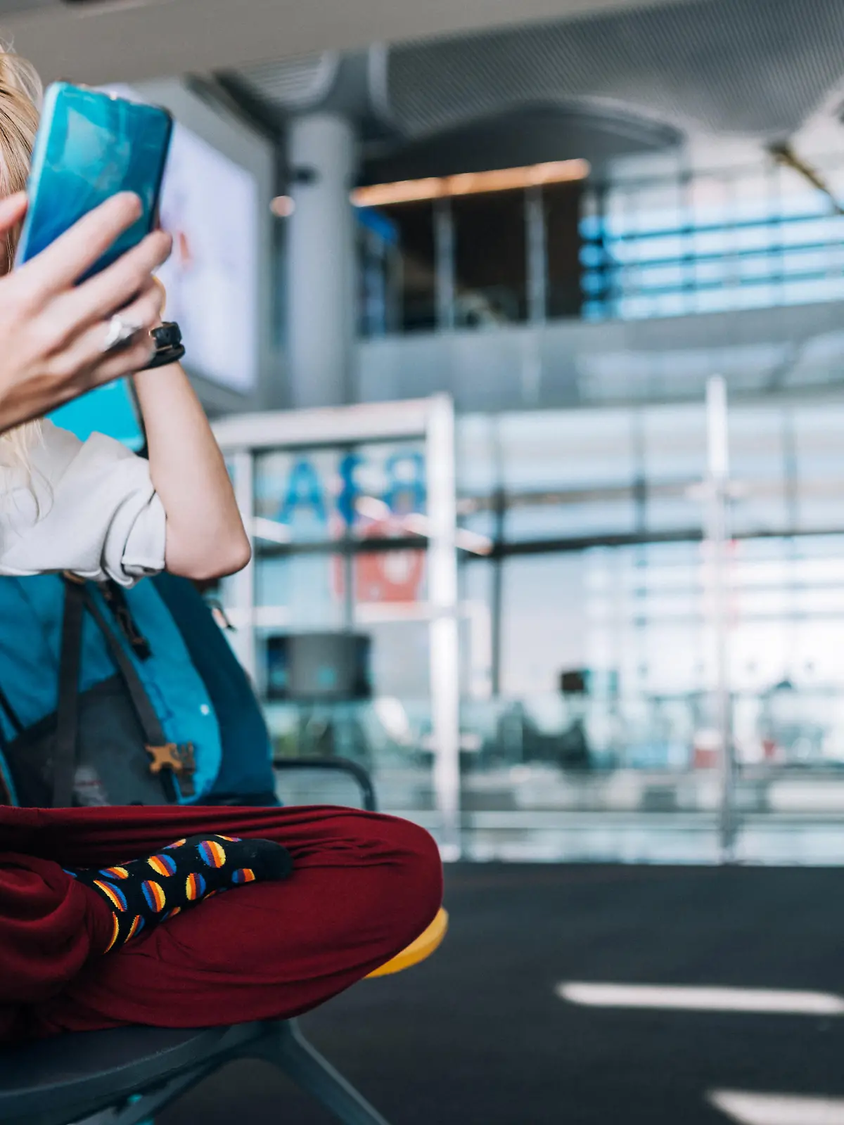 Young woman traveler, in a protective medical mask, sits in the waiting room and doing selfie, video chatting on smartphone
Traveling during Coronavirus pandemic