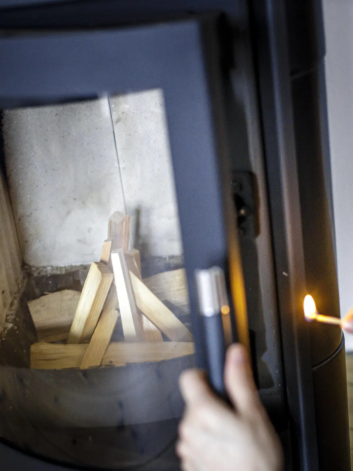 Symbolfoto: Eine Frau zuendet mit einem Streichholz einen Kaminofen an. Berlin, 21.02.2020 Berlin Deutschland *** Symbol photo A woman ends a stove with a match Berlin, 21 02 2020 Berlin Germany PUBLICATIONxINxGERxSUIxAUTxONLY Copyright: xThomasxTrutschel/photothek.dex 