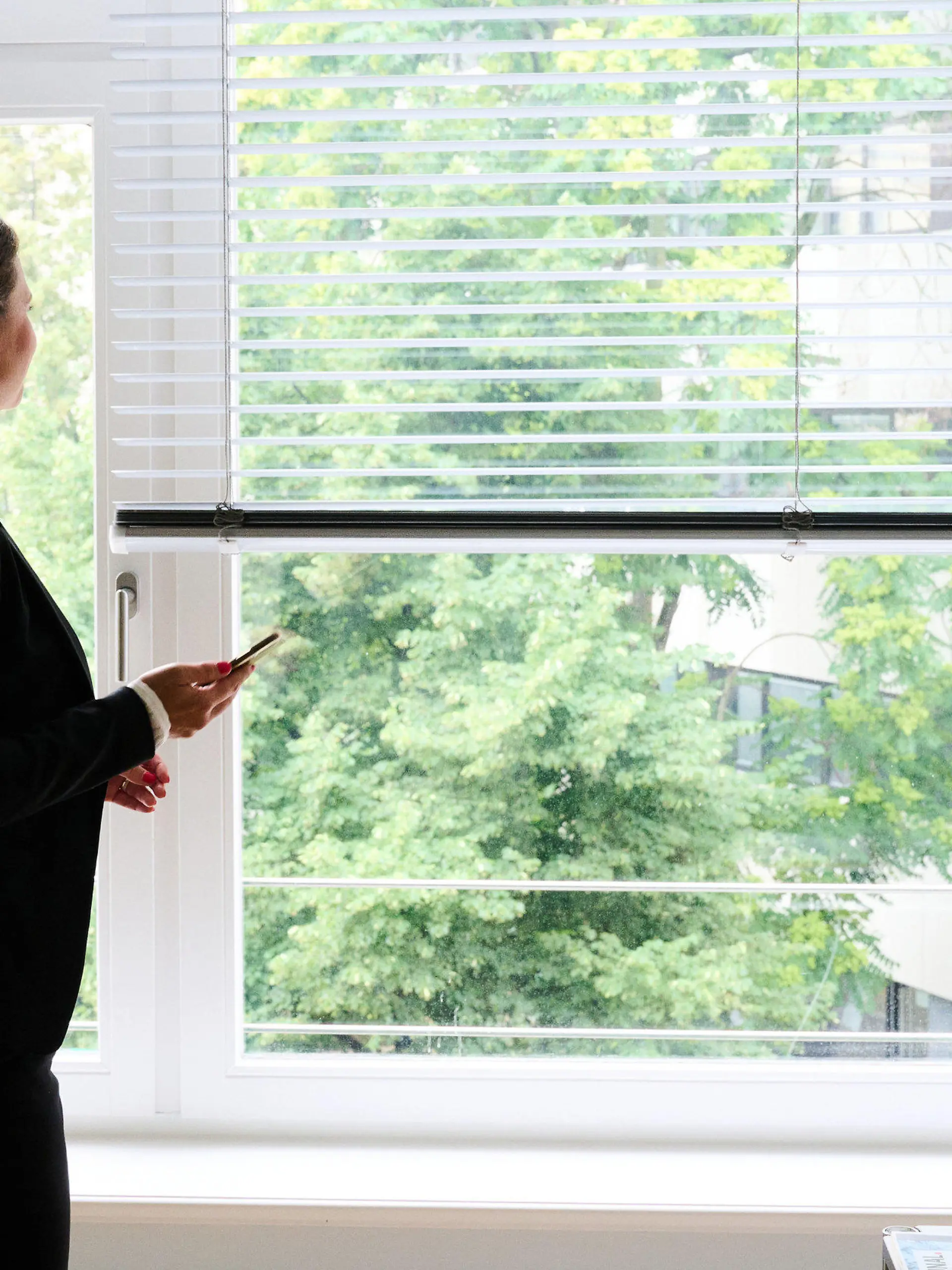 ARCHIV - 09.07.2021, Berlin: ILLUSTRATION - Eine Frau steht in einem Büro am Fenster und telefoniert über ein Headset (gestellte Szene). Der Anteil an Frauen in den Aufsichtsräten großer öffentlicher Unternehmen ist weiter leicht gestiegen, in den Vorständen gibt es dagegen im Jahresvergleich keine Bewegung. Das hat die Organisation «Frauen in die Aufsichtsräte» (Fidar) in einer Studie ermittelt, die Donnerstag (12.08.2021) vorgestellt wird. (Zu dpa «Frauenanteil in Führungsetagen öffentlicher Betriebe steigt leicht») Foto: Annette Riedl/dpa +++ dpa-Bildfunk +++