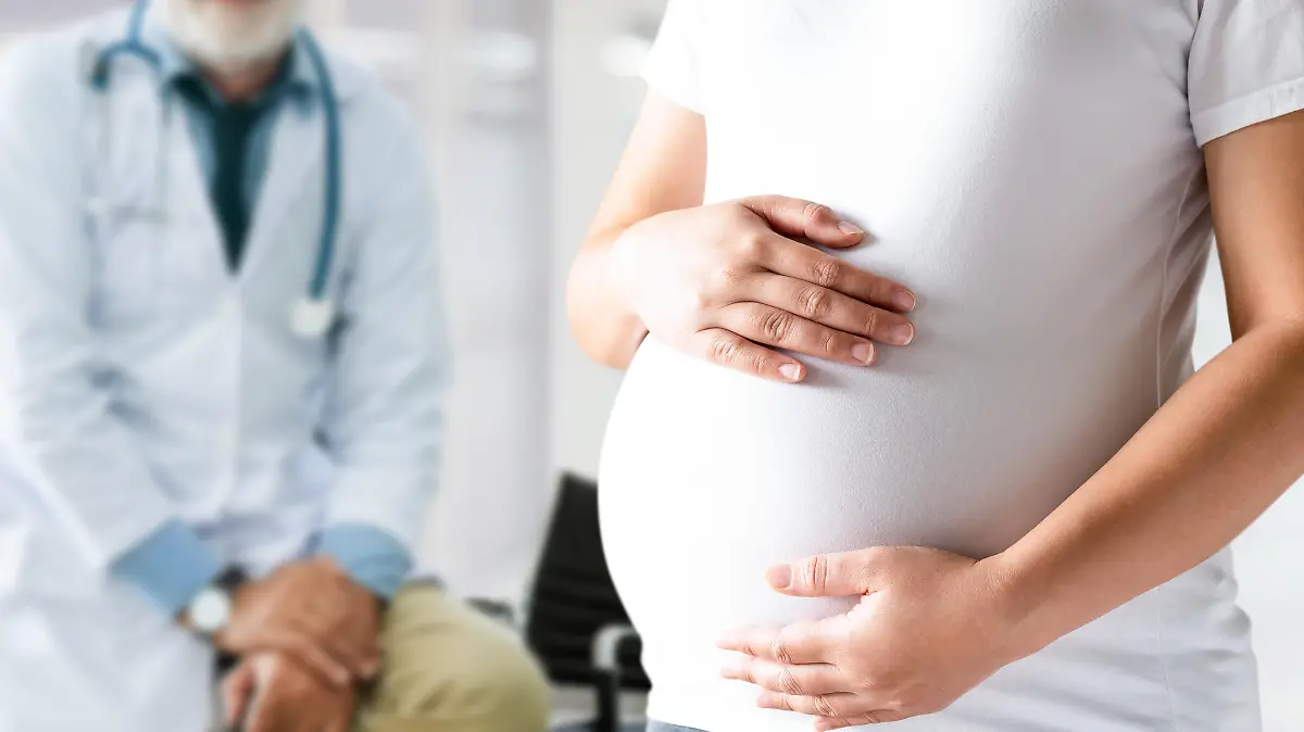 Happy pregnant woman visit gynecologist doctor at hospital or medical clinic for pregnancy consultant. Doctor examine pregnant belly for baby and mother healthcare check up. Gynecology concept.