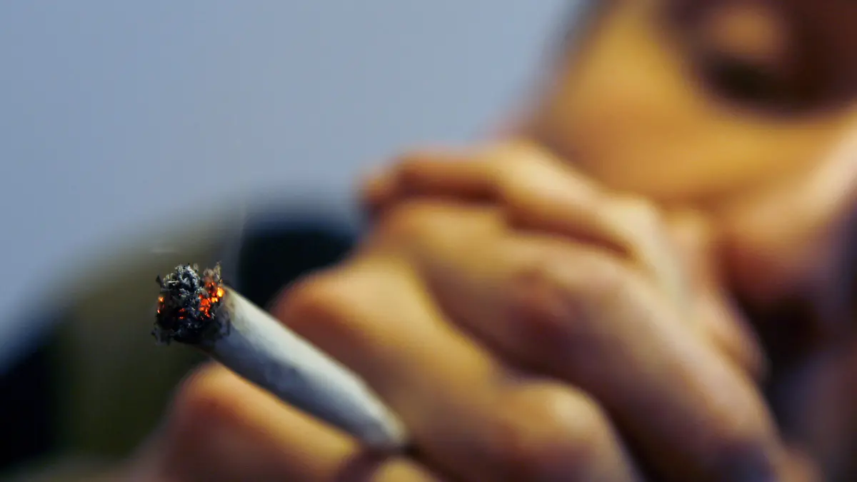 Ein Mann raucht einen Joint mit Marihuana, aufgenommen am 30.11.2006 in Würzburg (Unterfranken). Die harzverklebten getrockneten Pflanzenteile der weiblichen Cannabis-Pflanzen ergeben Marihuana, das geraucht rauschartige Zustände hervorruft. Foto: Daniel Karmann dpa/lby +++(c) dpa - Report+++