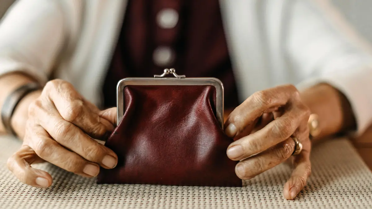 Old woman counting coins from her wallet