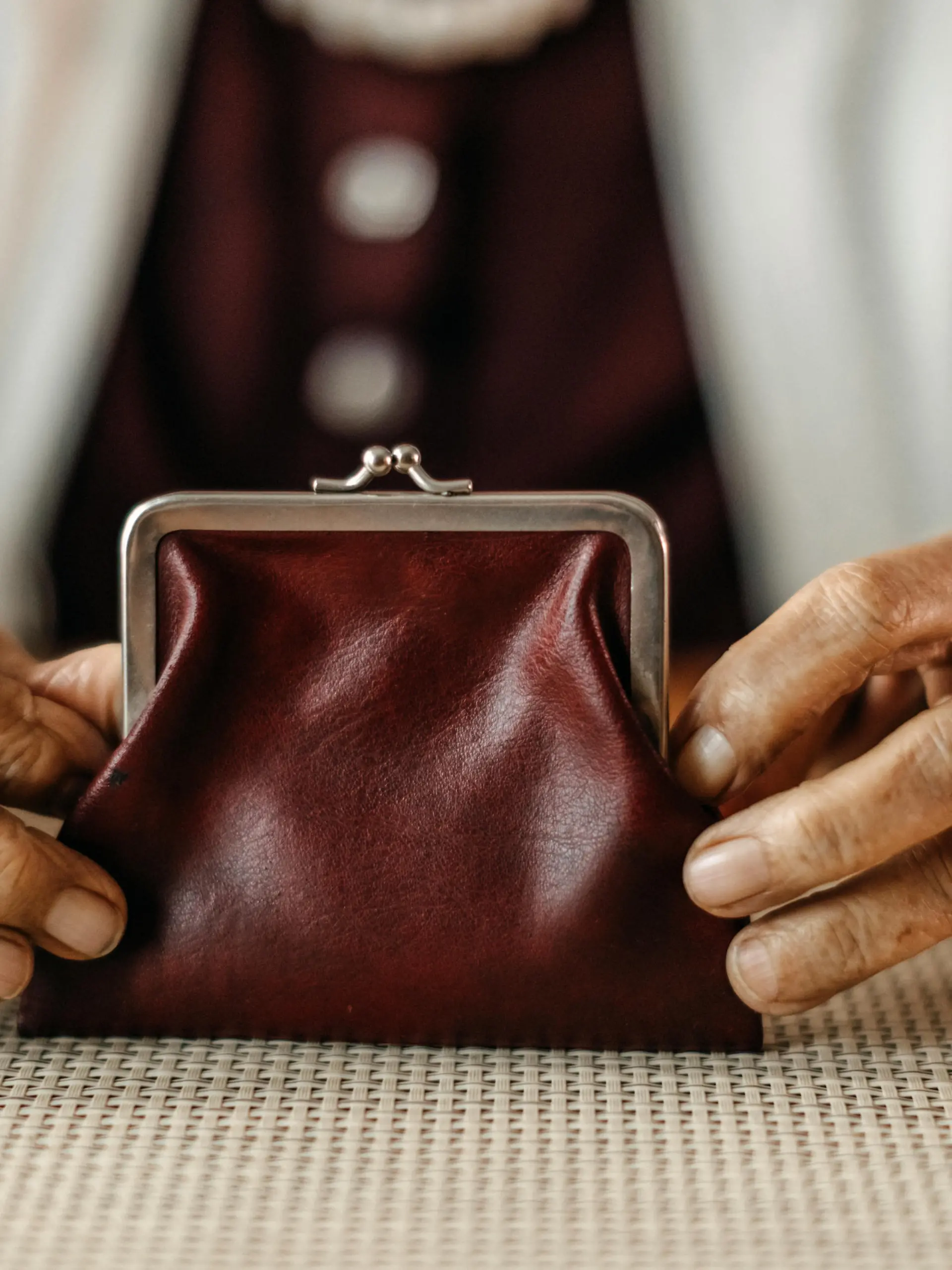 Old woman counting coins from her wallet