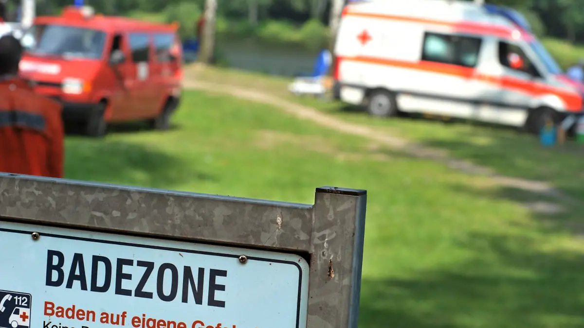 ARCHIV - Rettungskräfte stehen nach einem Badeunfall am 26.07.2012 am Hardausee (Kreis Uelzen; Niedersachsen). Nach einem weiteren Badeunfall in Niedersachsen hat die Deutsche Lebens-Rettungs-Gesellschaft (DLRG) Schwimmer zur Vorsicht in unbewachten Seen aufgerufen. Foto: Philipp Schulze/ dpa (zu lni "DLRG mahnt Schwimmer zur Vorsicht in unbewachten Seen" vom 04.08.2014) +++(c) dpa - Bildfunk+++