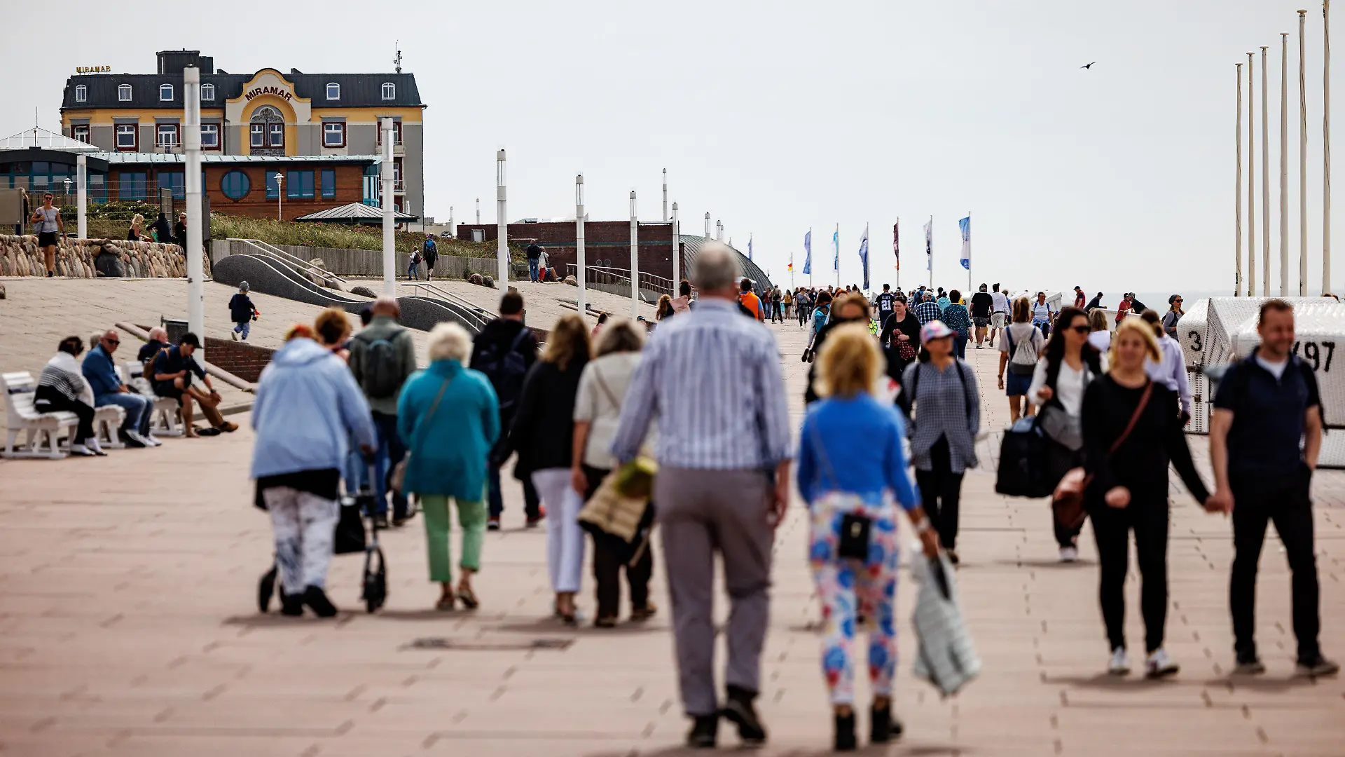 05.06.2022, Schleswig-Holstein, Westerland/Sylt: Besucher der Insel Sylt gehen über die Strandpromenade. Durch die Einführung des 9-Euro-Tickets haben sich die traditionell hohen Touristenzahlen an Pfingsten noch einmal erhöht. Foto: Axel Heimken/dpa +++ dpa-Bildfunk +++