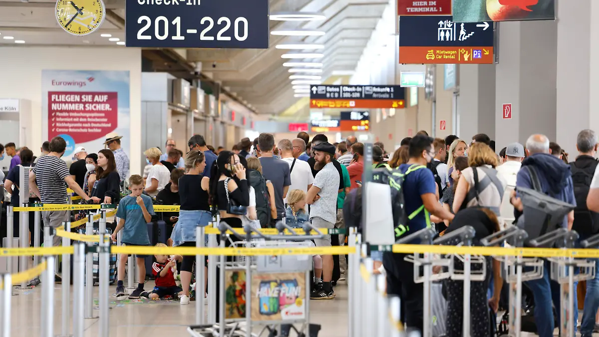 ARCHIV - 25.06.2022, Nordrhein-Westfalen, Köln: Passagiere stehen am Samstag Vormittag in einer Schlange von mehreren hundert Metern für die Sicherheitskontrolle am Flughafen Köln Bonn an. Zur Bewältigung des Abfertigungschaos im Luftverkehr wollen die deutschen Flughäfen und ihre Bodendienstleister tausende ausländische Aushilfen direkt anstellen. (zu dpa «Flughäfen und Dienstleister wollen Aushilfen direkt anstellen») Foto: Thomas Banneyer/dpa +++ dpa-Bildfunk +++