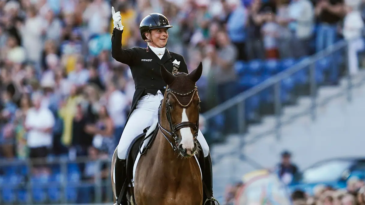 28.06.2022, Nordrhein-Westfalen, Aachen: Pferdesport: CHIO, Eröffnungsfeier. Die deutsche Dressurreiterin Isabell Werth auf ihrem Pferd Bella Rose winkt bei der Verabschiedung ihres Erfolgspferdes ins Publikum. Foto: Uwe Anspach/dpa +++ dpa-Bildfunk +++