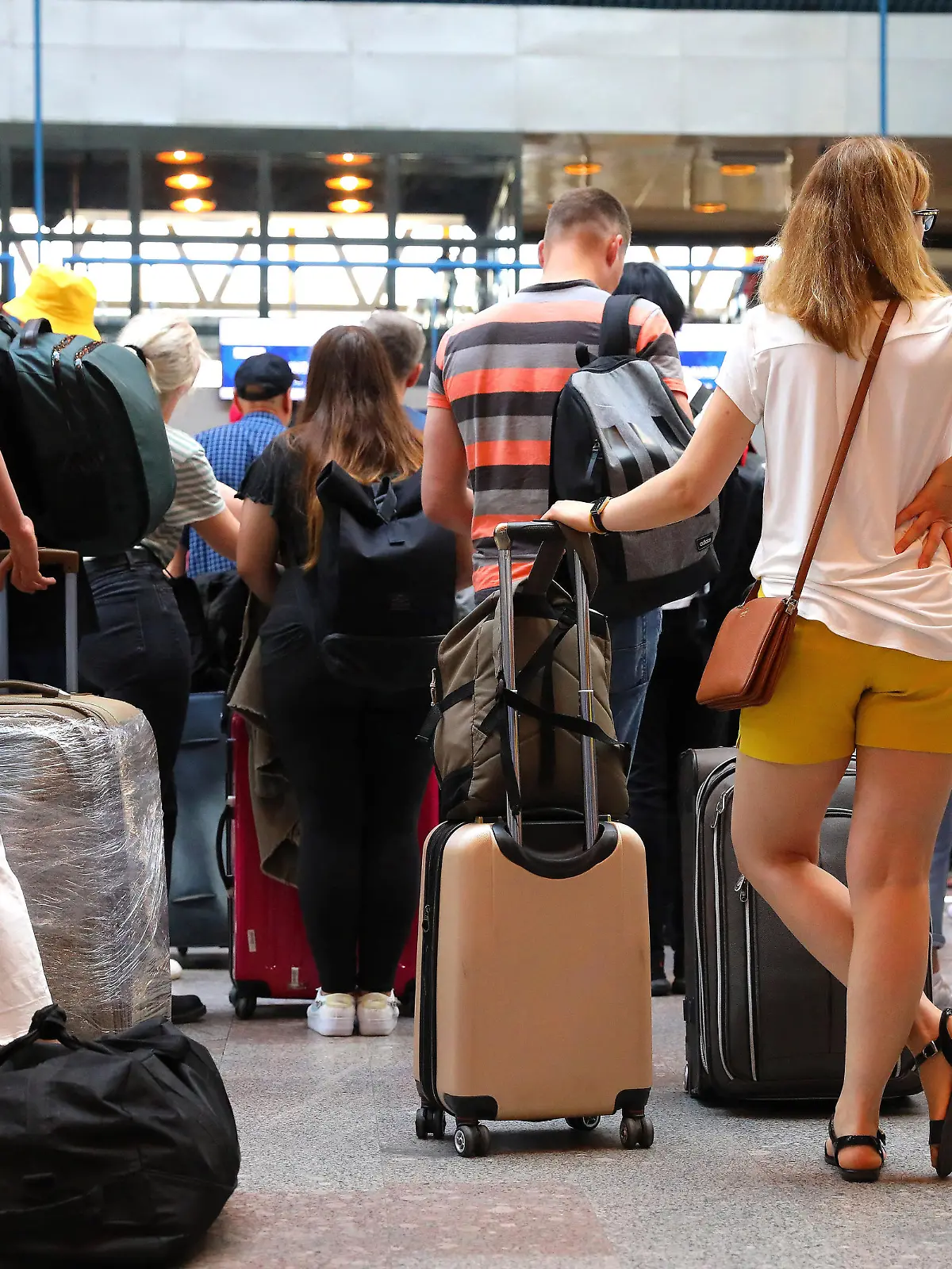 Passagiere checken ihre Koffer ein und müssen warten. Das Reiseaufkommen in diesem Sommer an den internationalen Flughäfen ist hoch.