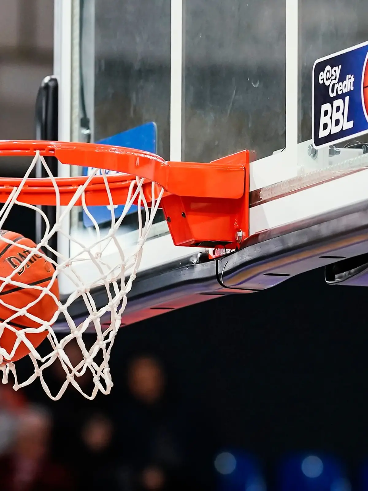 Ein Basketball landet im Netz.