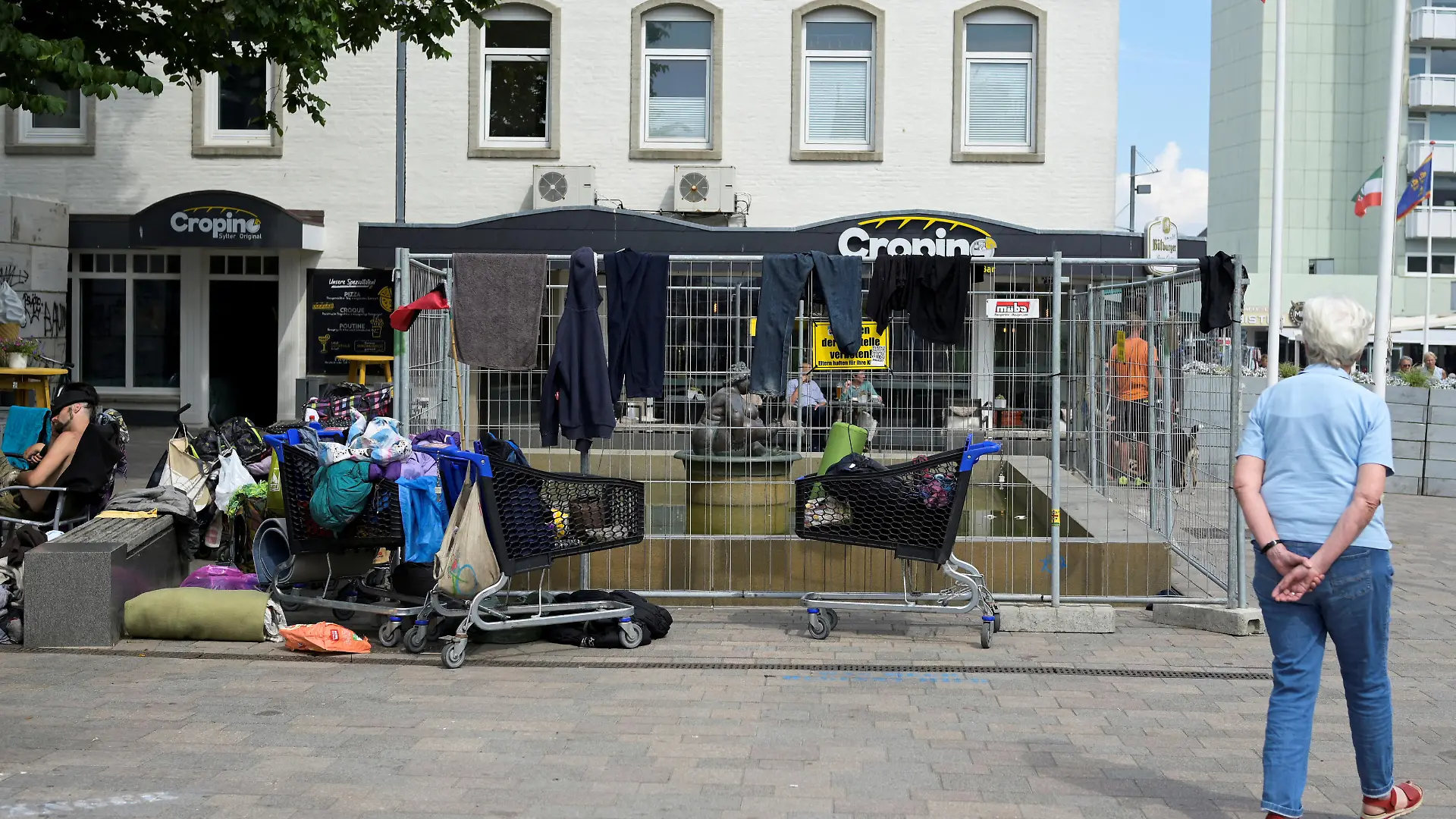 A public fountain is surrounded by a fence, where dozens of punks took over a place, who travelled with a special nine euro ticket from Deutsche Bahn, a German national railway company, that allows the usage of local buses and trains nationwide for a month, in downtown Westerland on the German island of Sylt, Germany, June 25, 2022. REUTERS/Fabian Bimmer