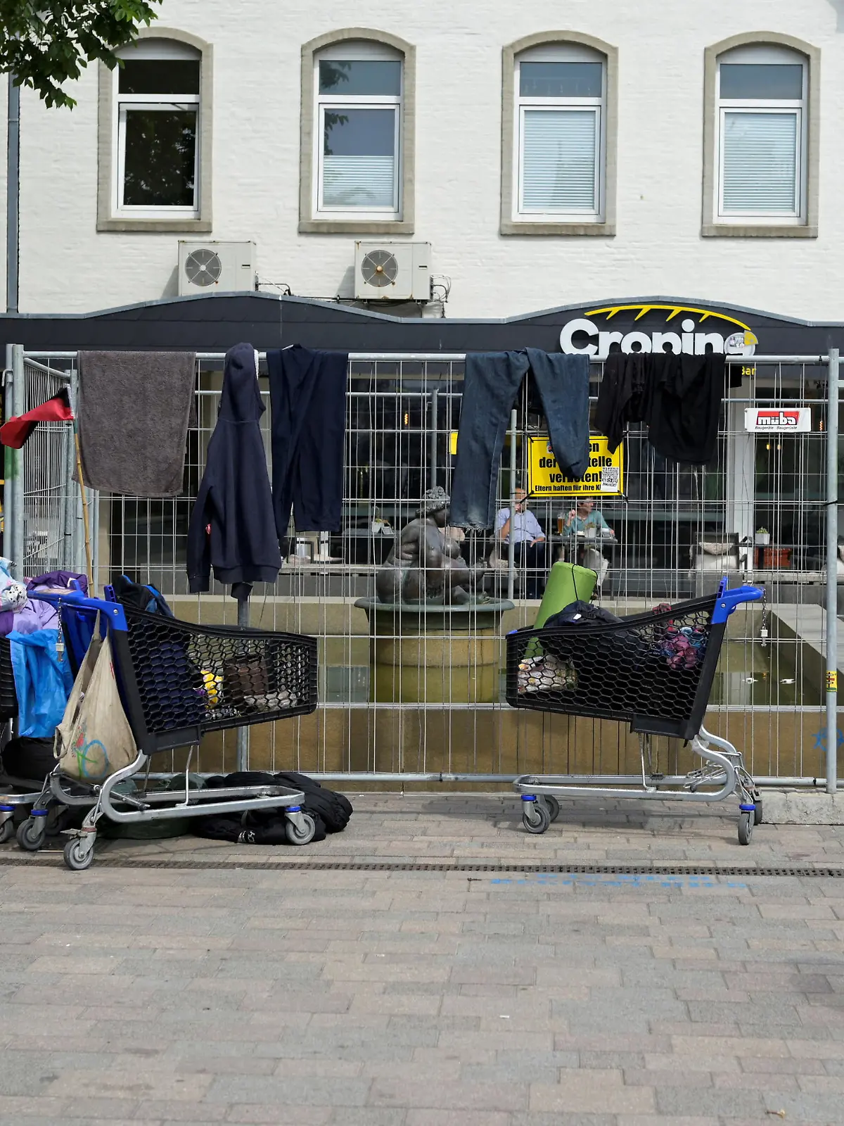A public fountain is surrounded by a fence, where dozens of punks took over a place, who travelled with a special nine euro ticket from Deutsche Bahn, a German national railway company, that allows the usage of local buses and trains nationwide for a month, in downtown Westerland on the German island of Sylt, Germany, June 25, 2022. REUTERS/Fabian Bimmer